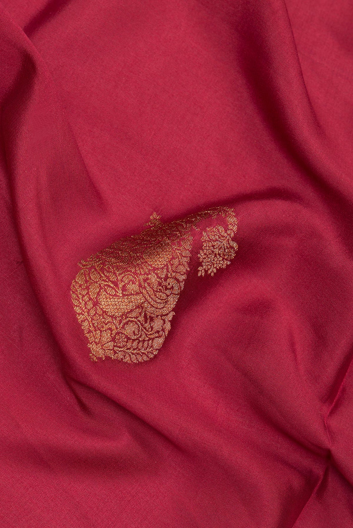 Close up of Maroon Crepe Saree with Zari Butta on the body and Zari Border.  displaying folds