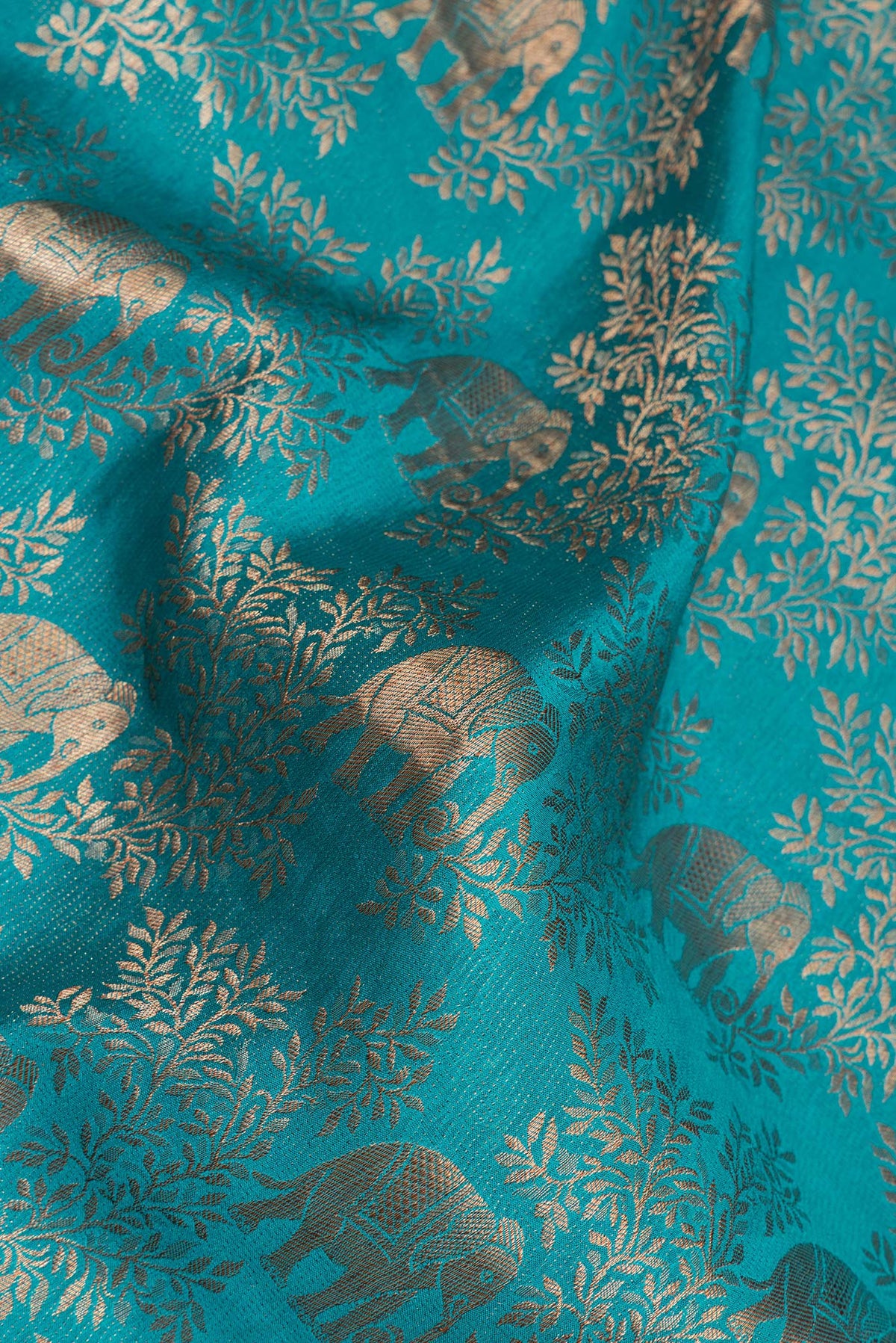 Close up of Teal Mysore Crepe Saree with Zari Brocade on the body and Zari And Thread Border.  displaying folds