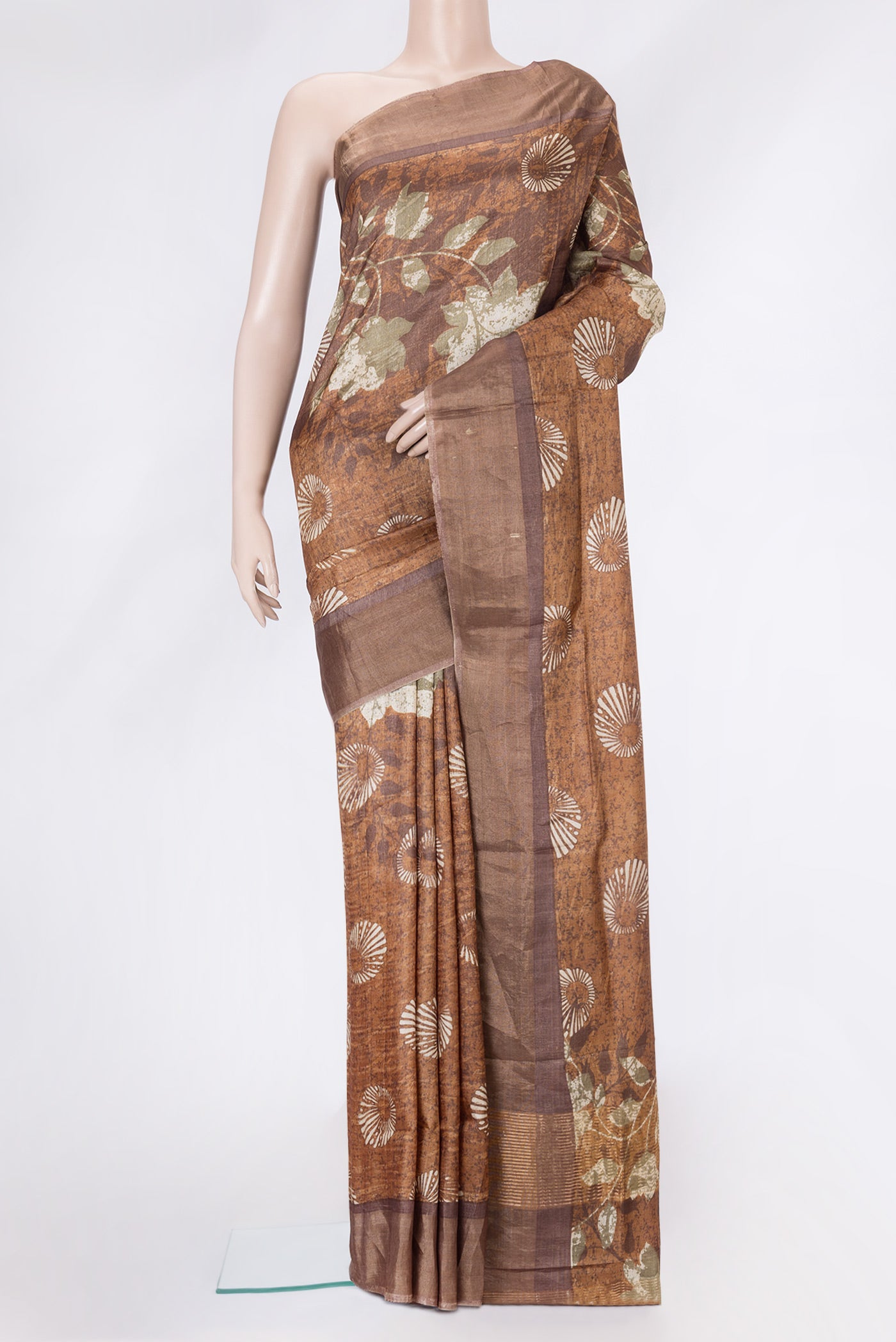 Brown Tussar Silk Saree with Printed design on the body and Zari Border.  displayed on a mannequin