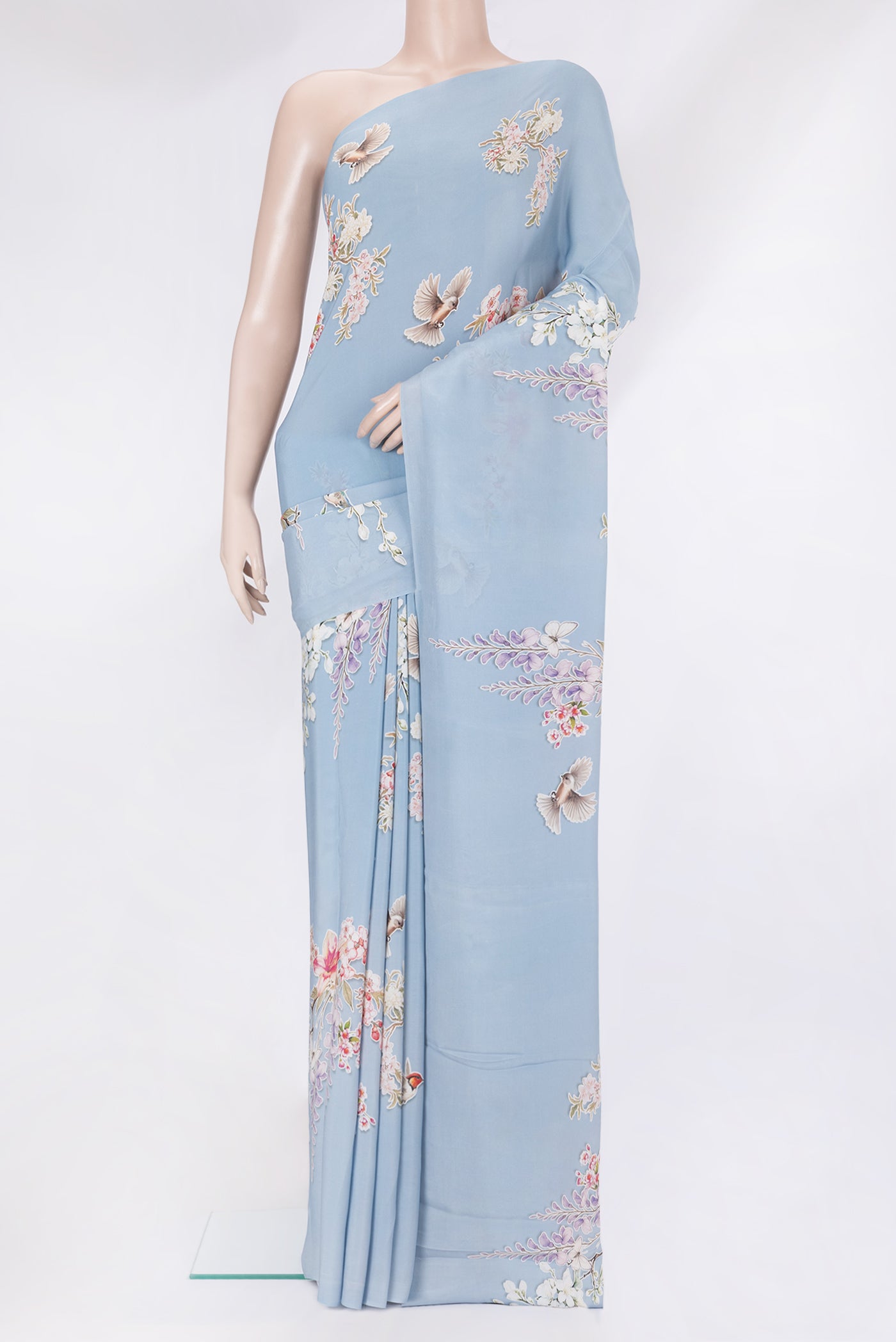 Light Blue Crepe Saree with Printed design on the body and Without Border.  displayed on a mannequin