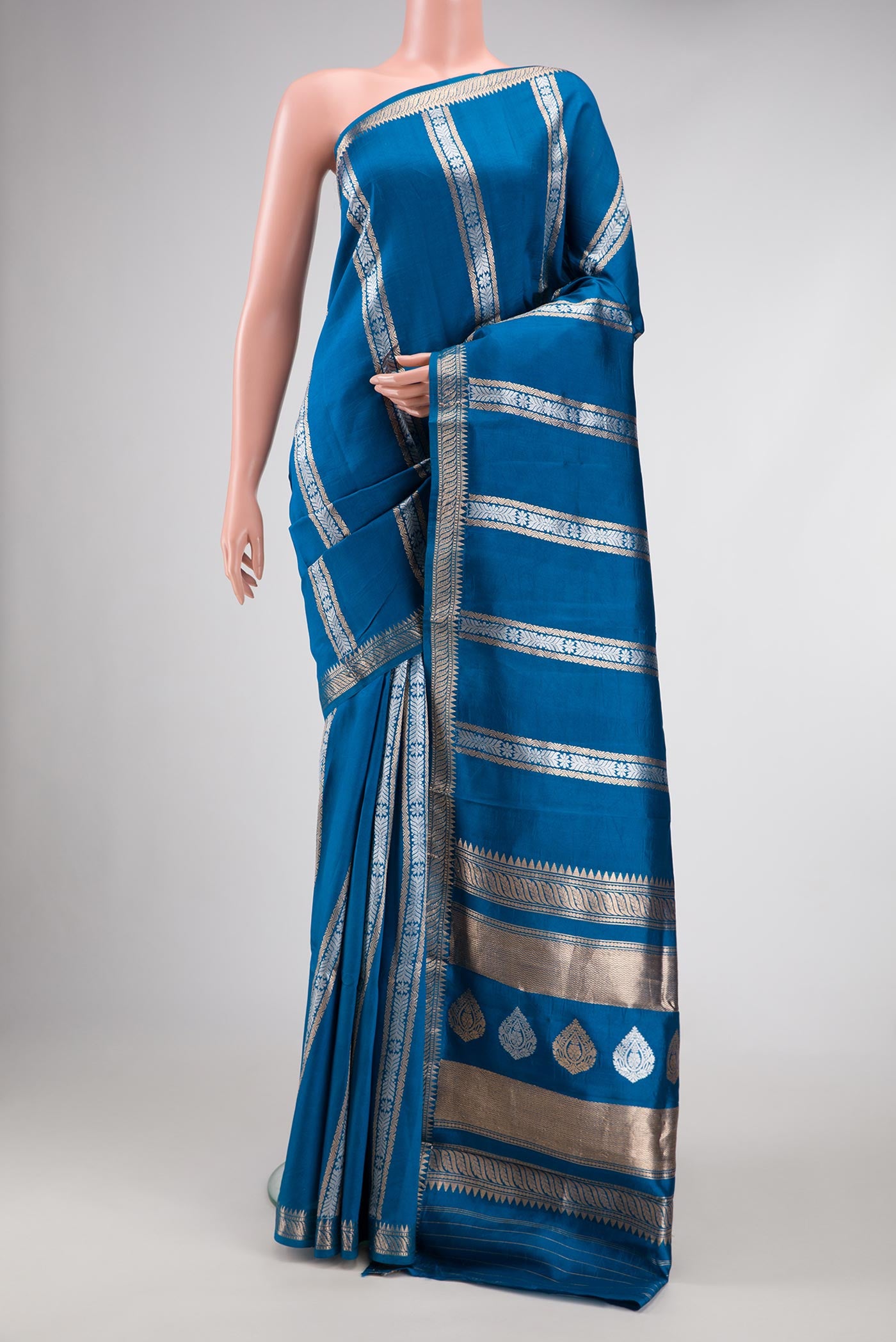 Peacock Blue Dual Tone Tussar Silk Saree with Stripes on the body and Zari Border.  displayed on a mannequin