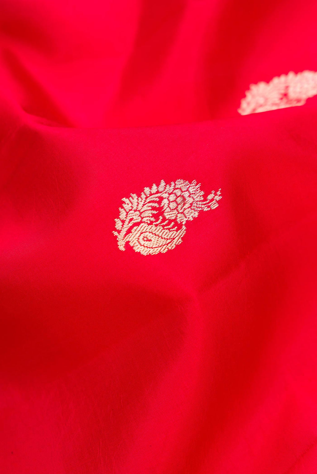 Close up of Red Dual Tone Tussar Silk Saree with Zari Butta on the body and Fancy Border.  displaying folds
