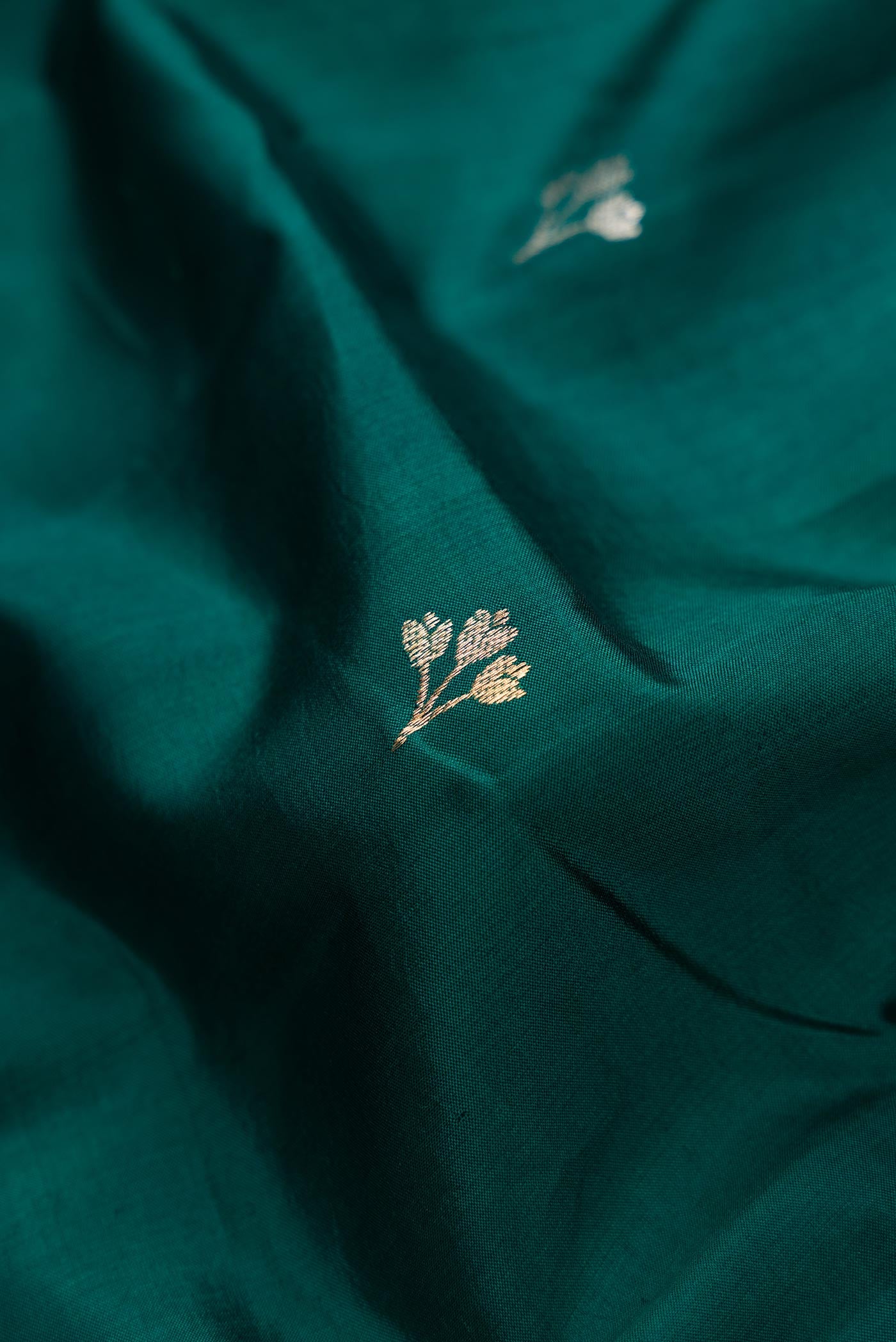 Close up of Bottle Green Dual Tone Tussar Silk Saree with Zari Butta on the body and Fancy Border.  displaying folds