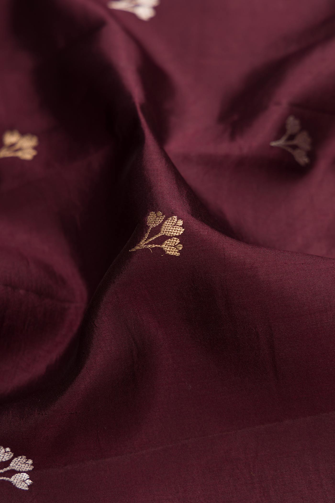 Close up of Coffee Brown Dual Tone Tussar Silk Saree with Zari Butta on the body and Fancy Border.  displaying folds