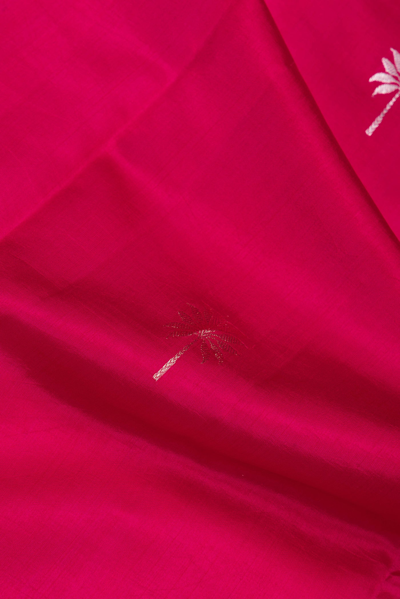 Close up of Dark Pink Dual Tone Tussar Silk Saree with Zari Butta on the body and Fancy Border.  displaying folds
