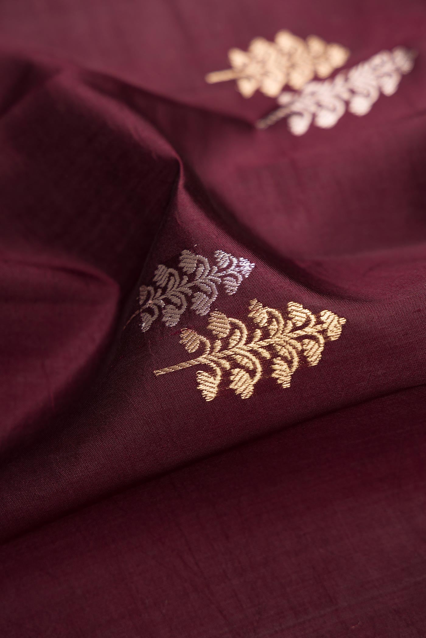 Close up of Coffee Brown Dual Tone Tussar Silk Saree with Zari Butta on the body and Fancy Border.  displaying folds