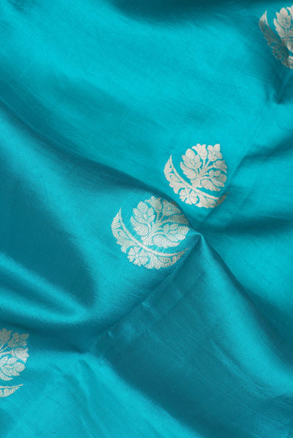 Close up of Sky Blue Tussar Silk Saree with Zari Butta on the body and Zari Border.  displaying folds