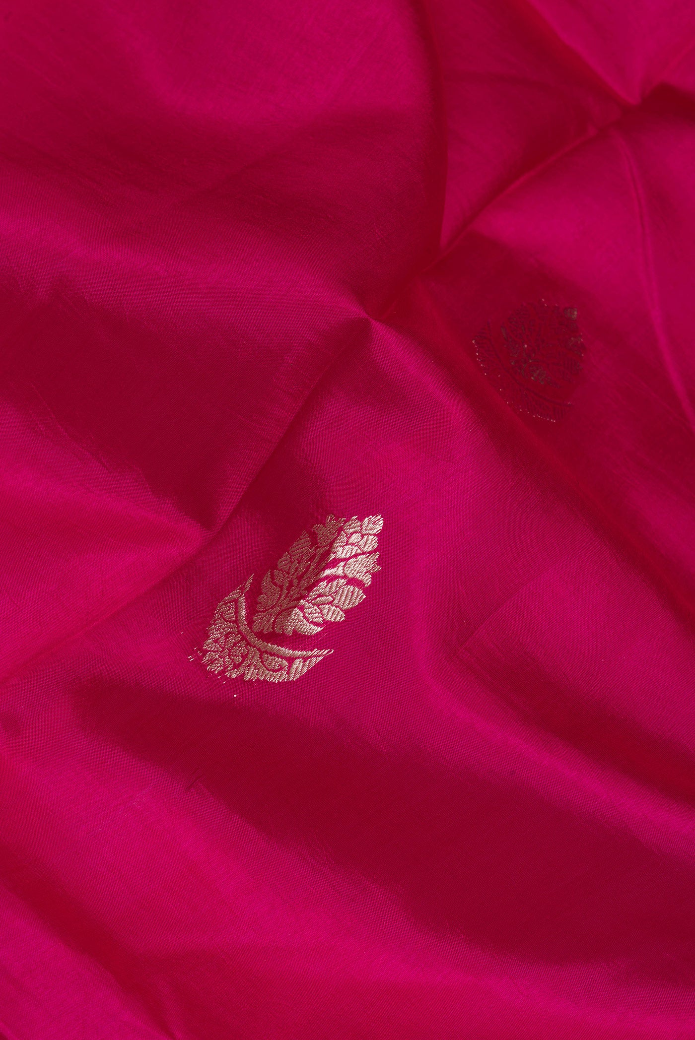 Close up of Dark Pink Dual Tone Tussar Silk Saree with Zari Butta on the body and Zari Border.  displaying folds