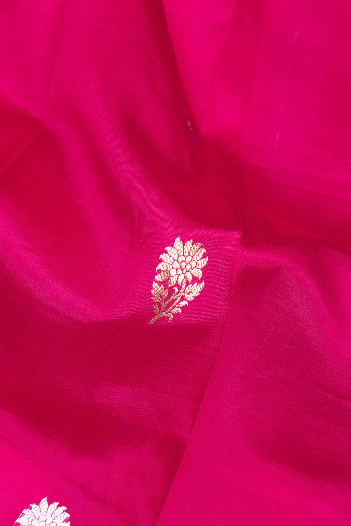 Close up of Dark Pink Tussar Silk Saree with Zari Butta on the body and Zari Border.  displaying folds