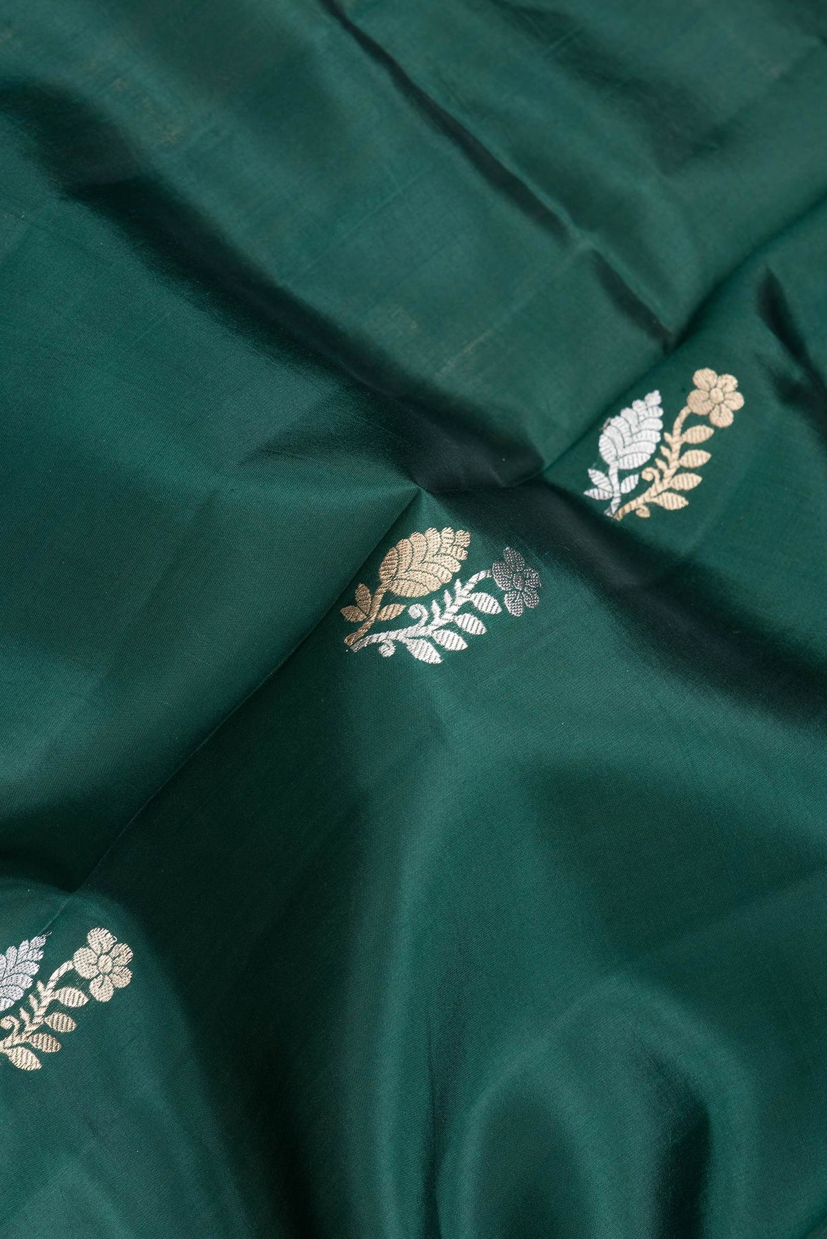 Close up of Bottle Green Dual Tone Tussar Silk Saree with Zari Butta on the body and Fancy Border.  displaying folds