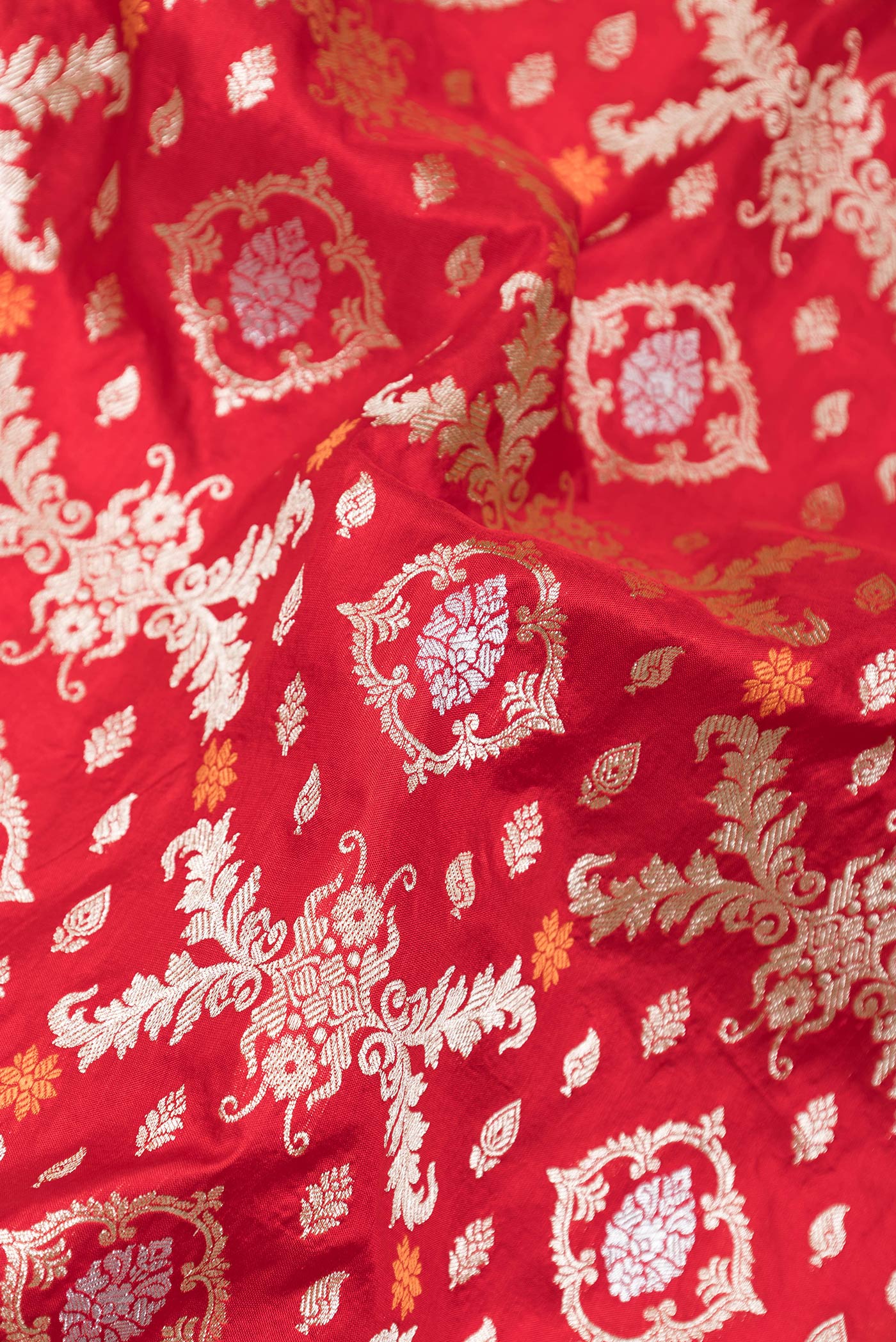Close up of Red Dual Tone Banarasi Silk Saree with Zari Brocade on the body and Zari Border.  displaying folds