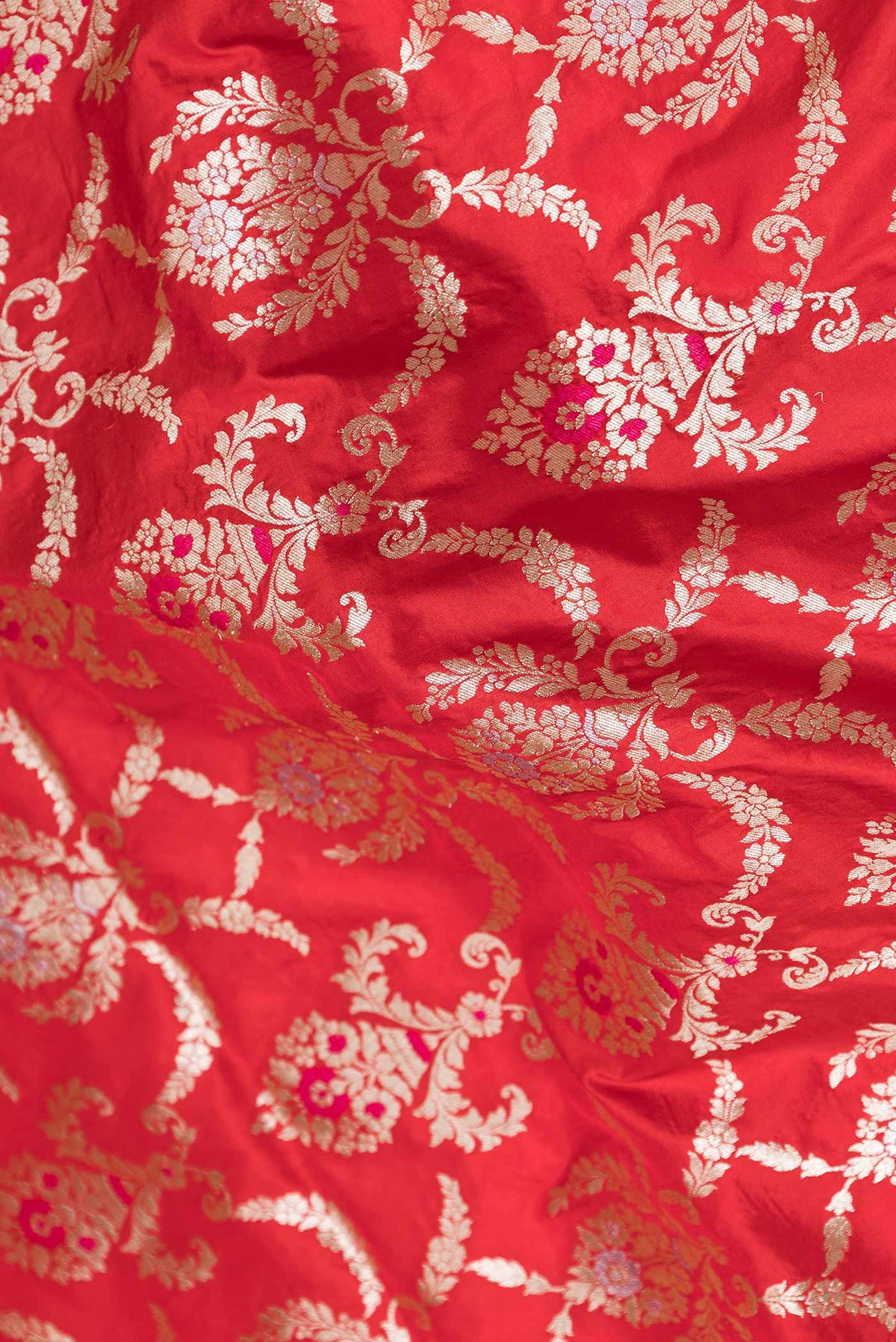 Close up of Red Dual Tone Banarasi Silk Saree with Zari Brocade on the body and Zari Border.  displaying folds