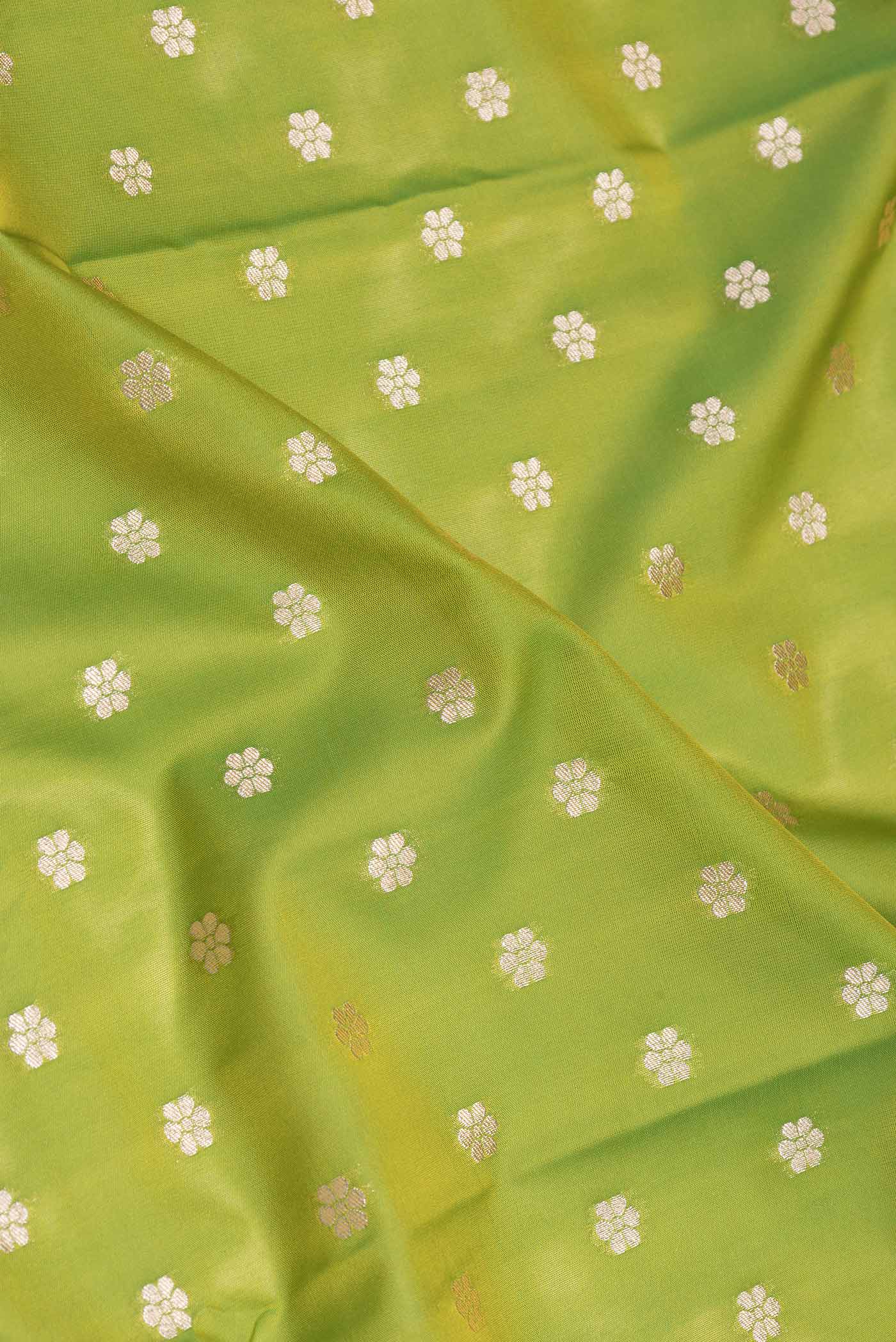 Close up of Parrot Green Dual Tone Blended Banarasi Saree with Zari Butta on the body and Zari Border.  displaying folds