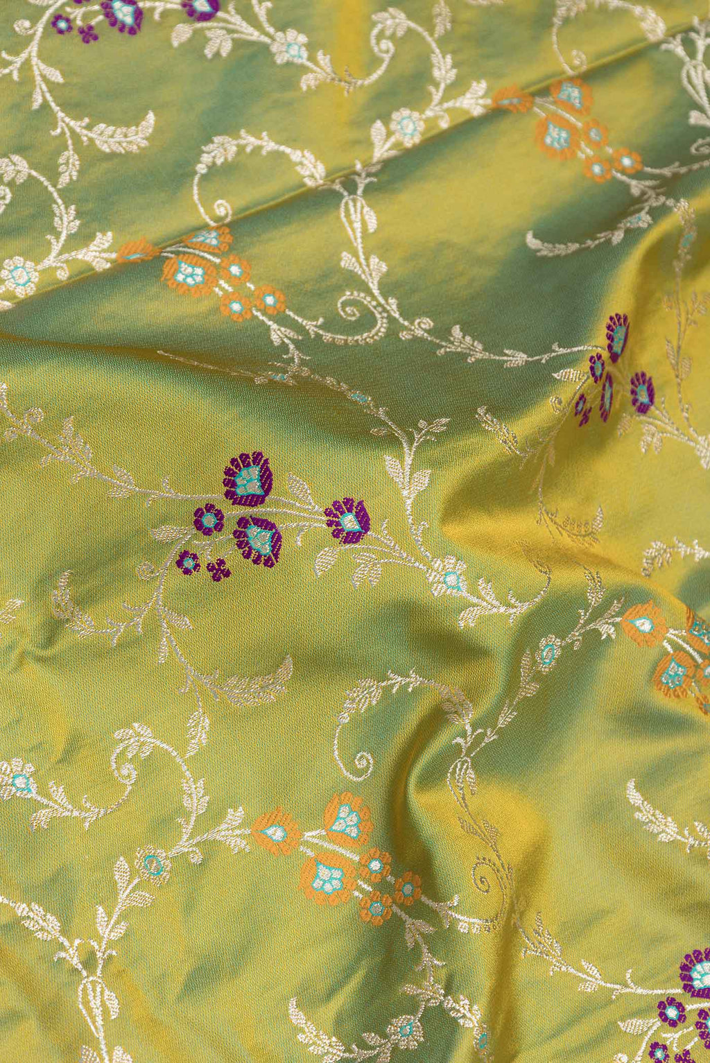 Close up of Parrot Green Dual Tone Blended Banarasi Saree with Zari Brocade on the body and Zari Border.  displaying folds