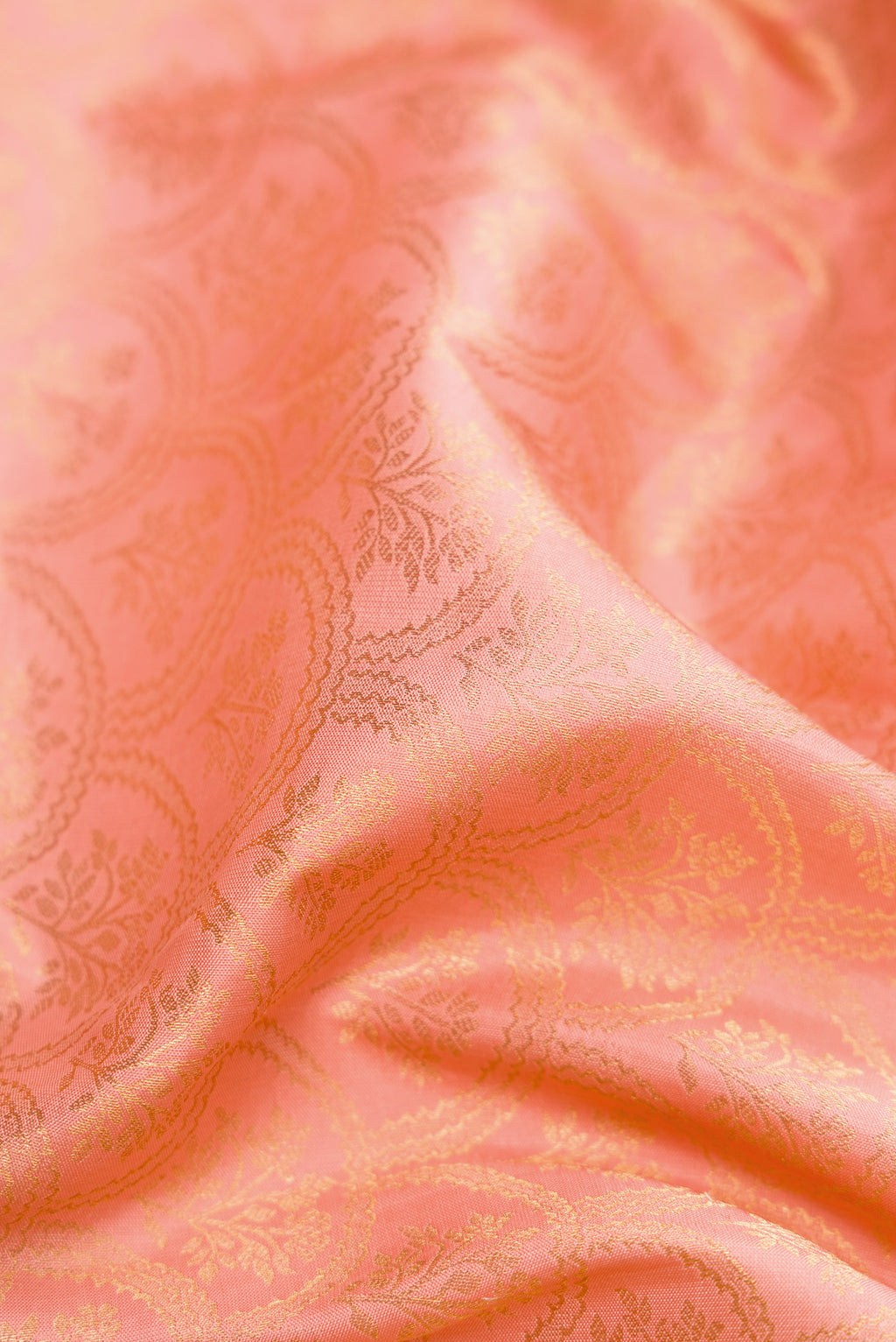 Close up of Peach Dual Tone Kanjivaram Silk Saree with Zari Brocade on the body and Zari Border.  displaying folds