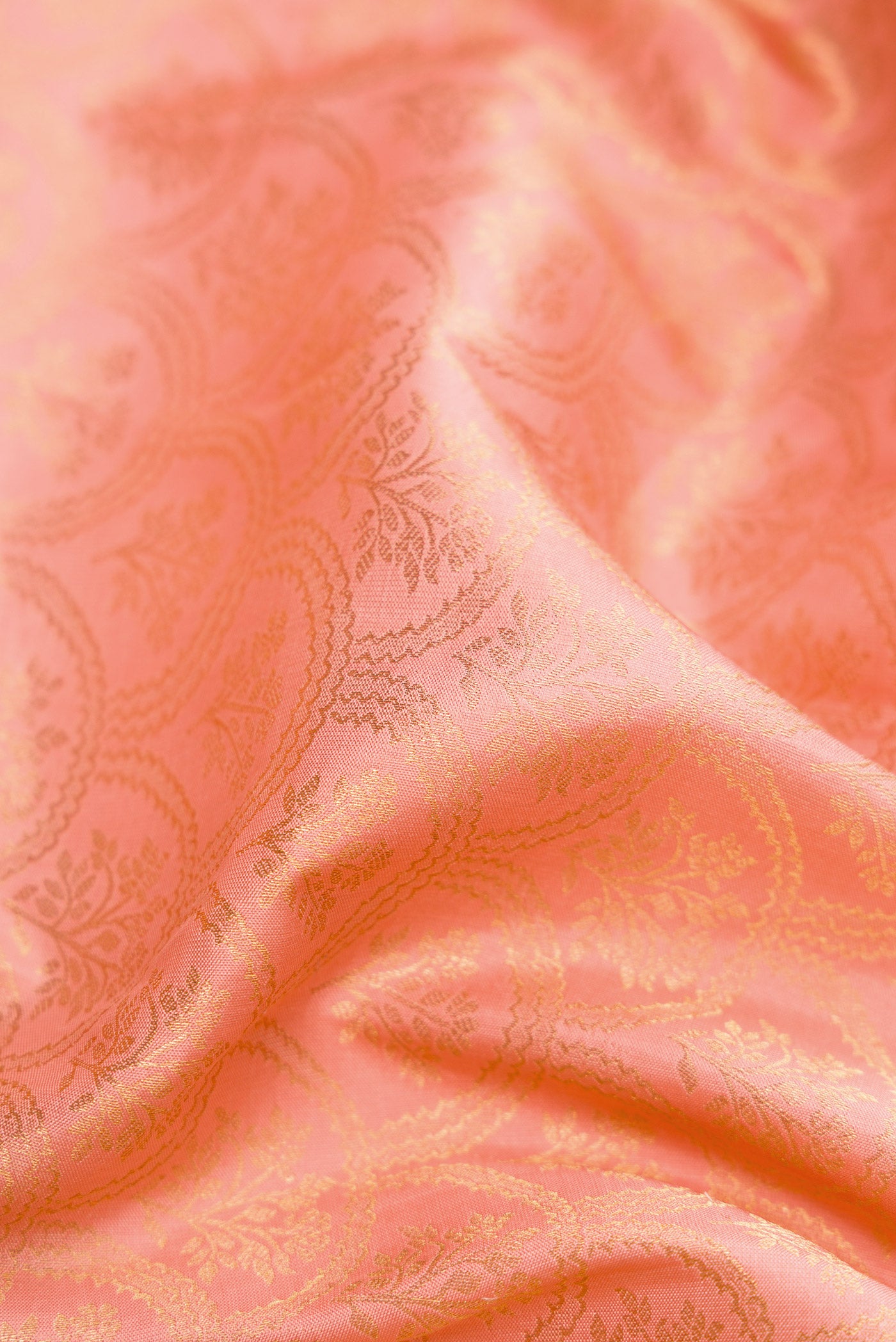 Close up of Peach Dual Tone Kanjivaram Silk Saree with Zari Brocade on the body and Zari Border.  displaying folds