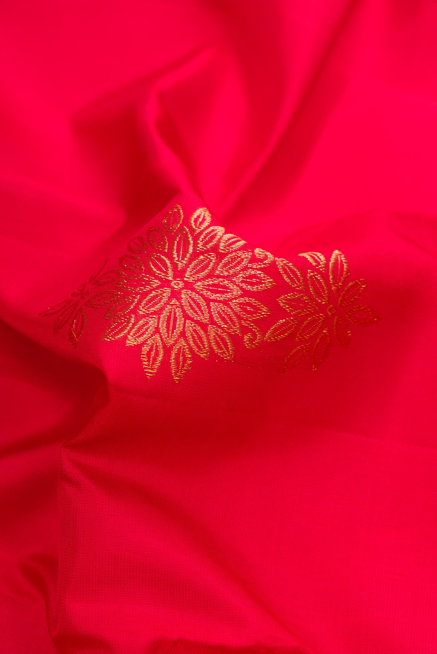 Close up of Red Dual Tone Kanjivaram Silk Saree with Zari Butta on the body and Fancy Border.  displaying folds