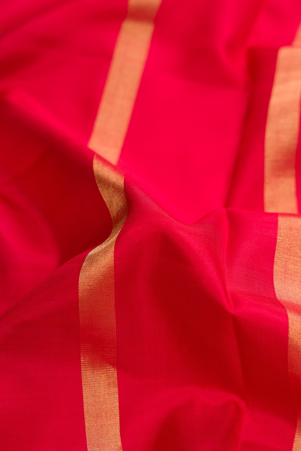 Close up of Red Dual Tone Soft Silk Saree with Stripes on the body and Ikat Border.  displaying folds