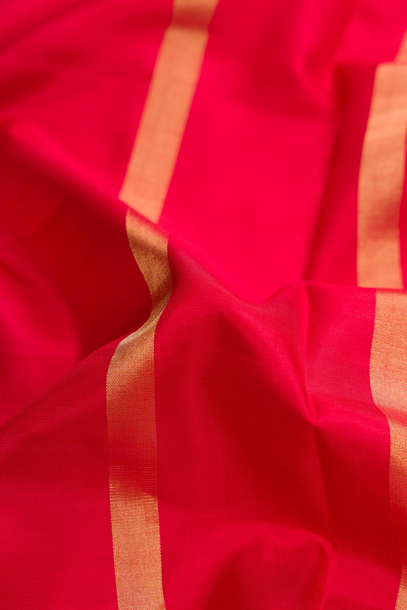Close up of Red Dual Tone Soft Silk Saree with Stripes on the body and Ikat Border.  displaying folds