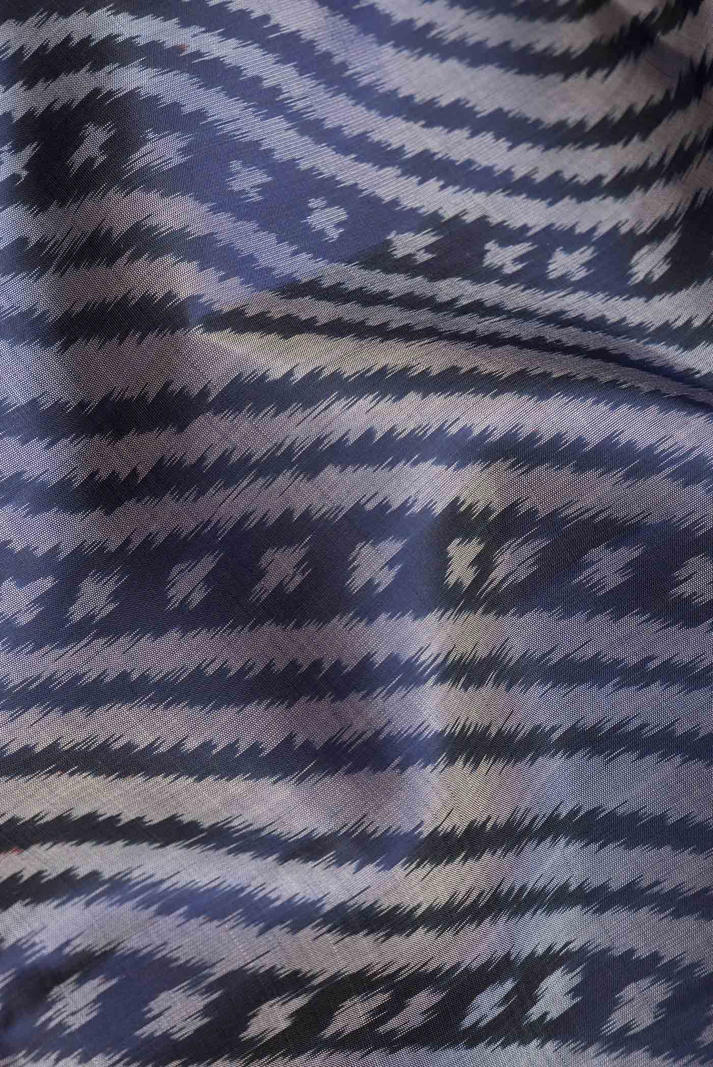 Close up of Navy Blue Dual Tone Soft Silk Saree with Ikat Print on the body and Ikat Border.  displaying folds