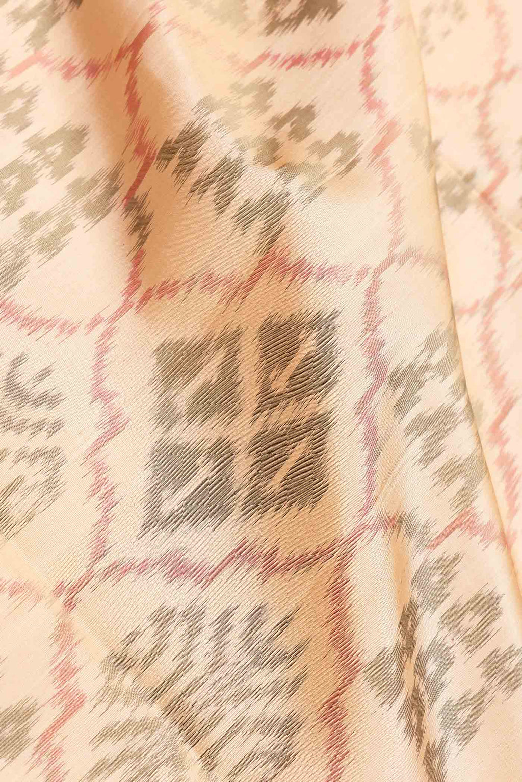 Close up of Beige Dual Tone Soft Silk Saree with Ikat Print on the body and Zari Border.  displaying folds