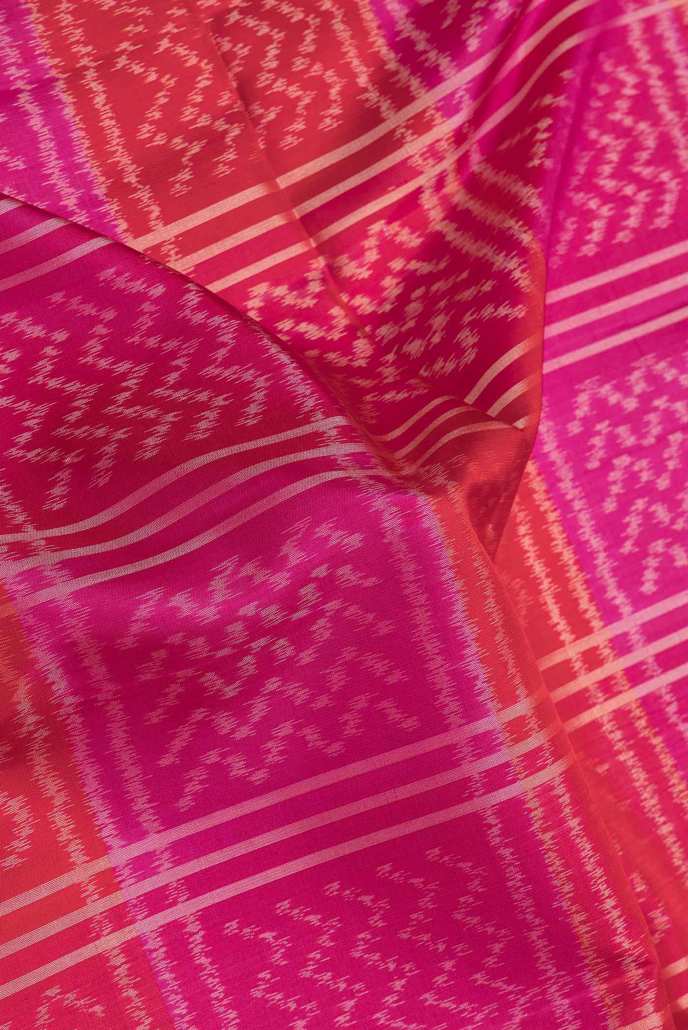 Close up of Pink Dual Tone Soft Silk Saree with Ikat Print on the body and Zari Border.  displaying folds