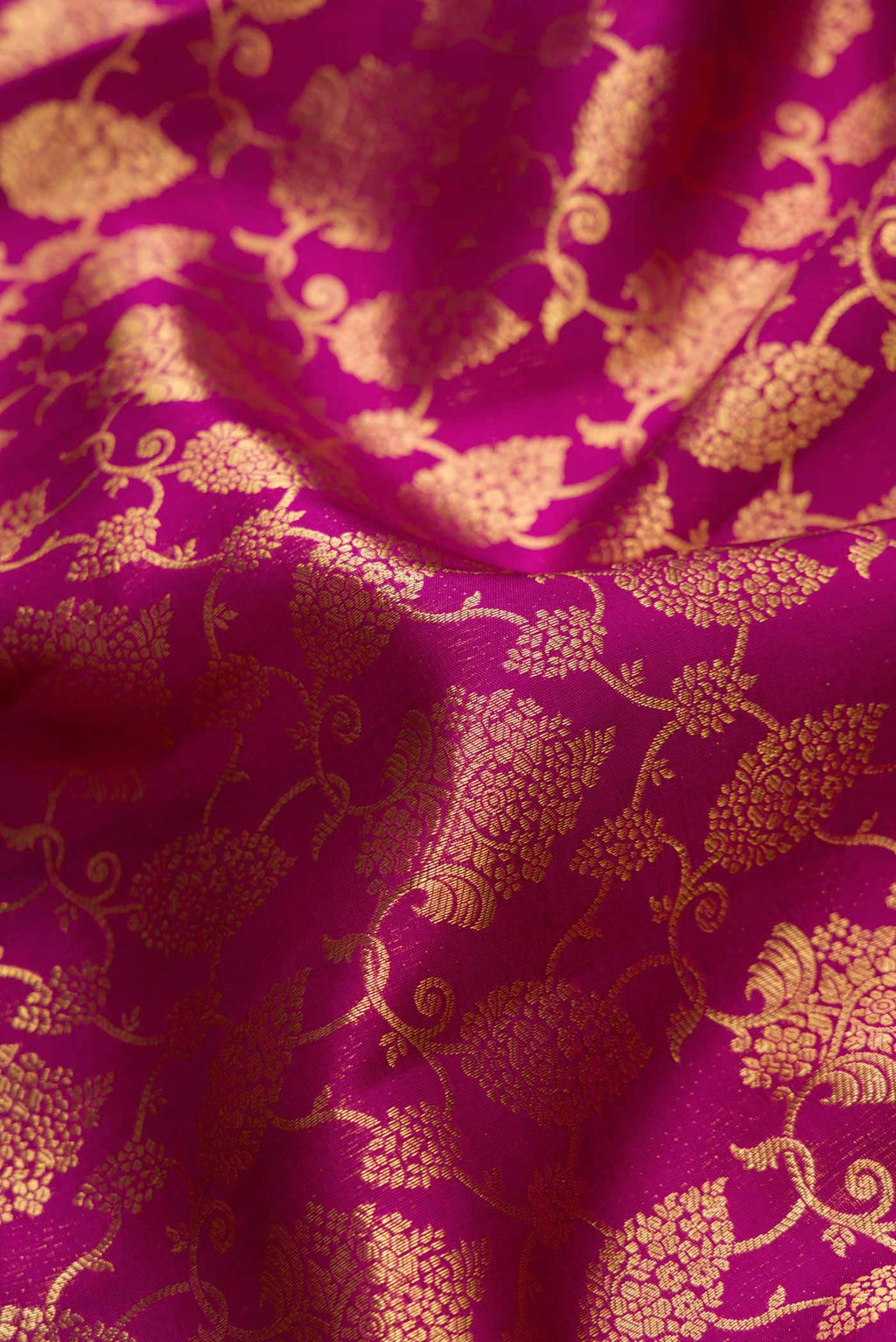 Close up of Magenta Dual Tone Kanchipuram Silk Saree with Zari Brocade on the body and Zari Border.  displaying folds