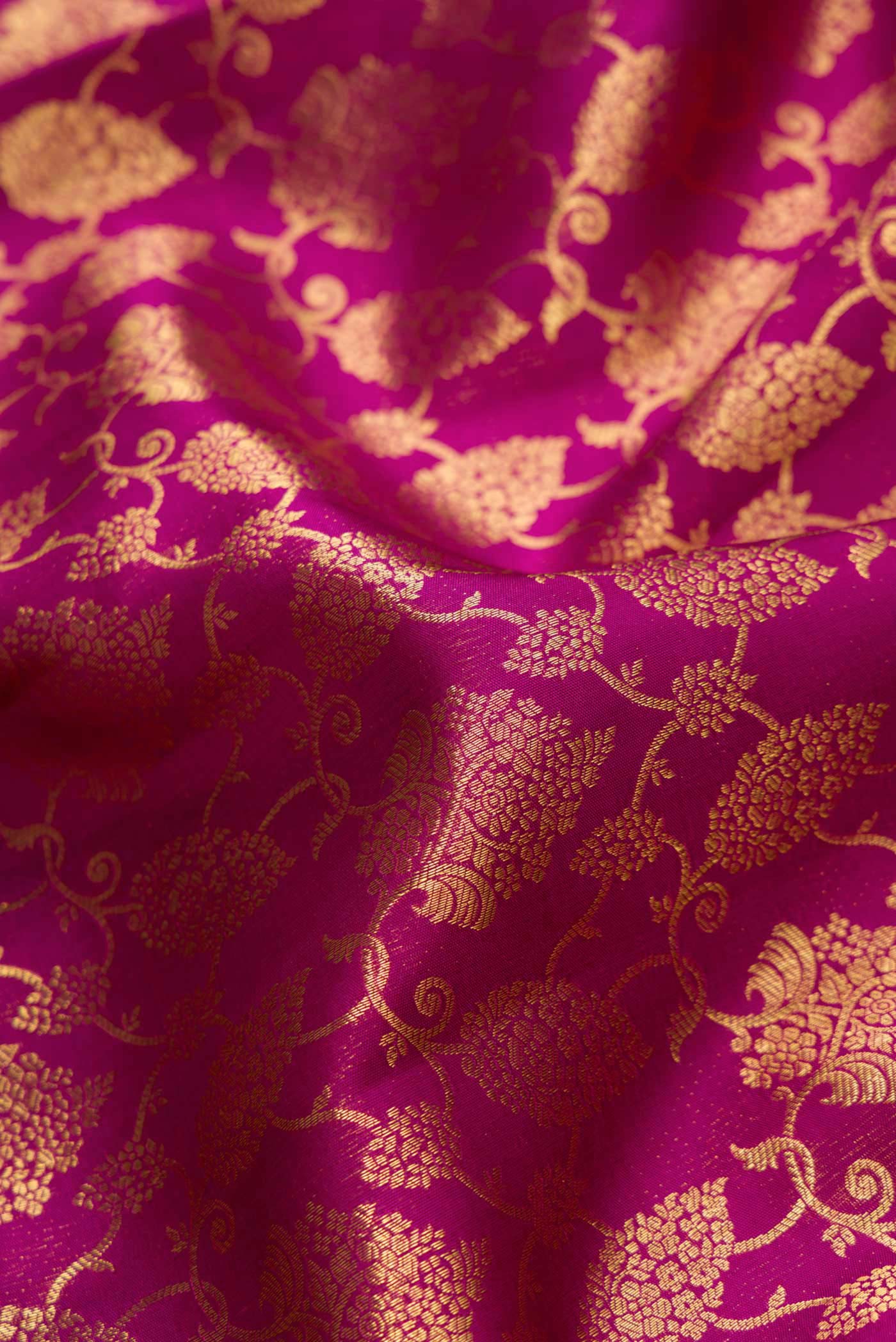 Close up of Magenta Dual Tone Kanchipuram Silk Saree with Zari Brocade on the body and Zari Border.  displaying folds