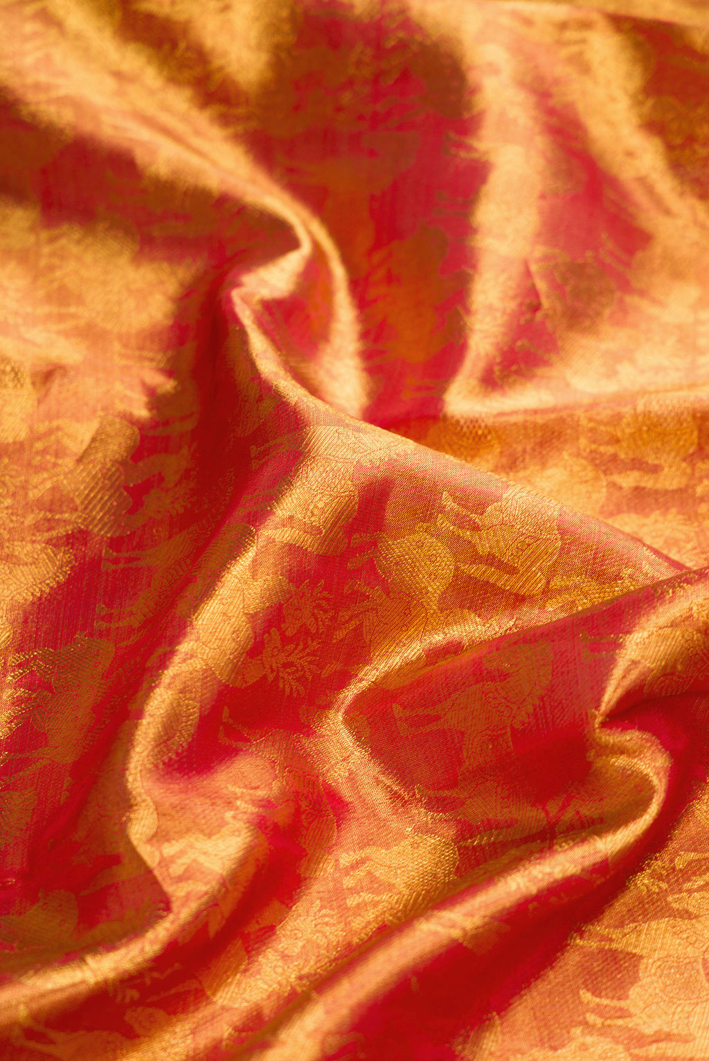 Close up of Maroon Dual Tone Kanjivaram Tissue Silk Saree with Zari Brocade on the body and Zari Border.  displaying folds