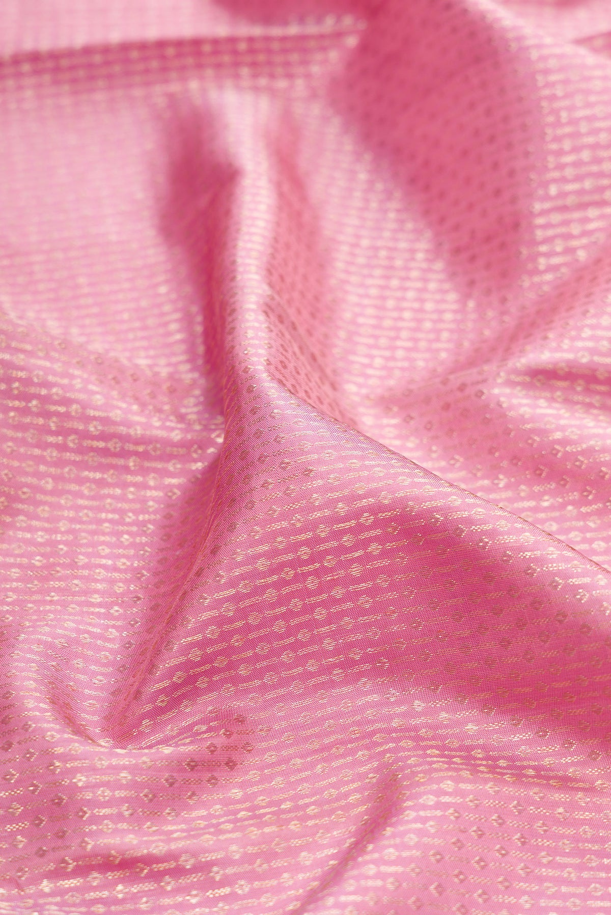 Close up of Pink Kanchipuram Silk Saree with Zari Brocade on the body and Zari Border.  displaying folds