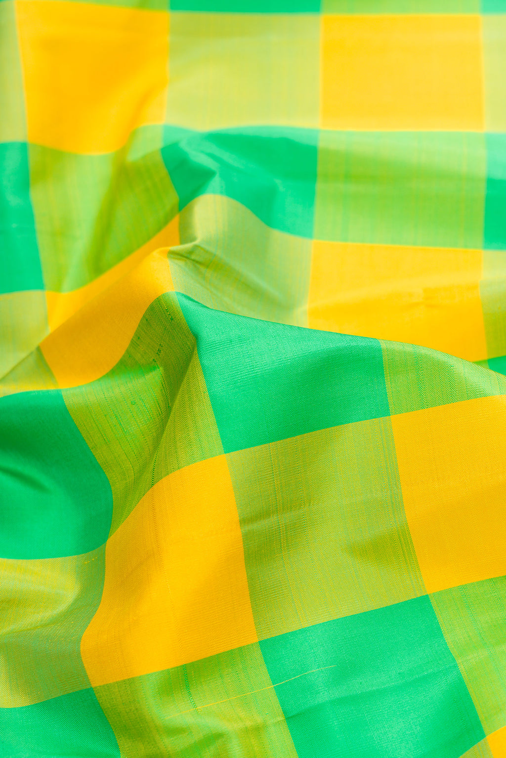 Close up of Yellow and Green Color Kanjivaram Silk Saree with Checked design on the body and Temple Border.  displaying folds