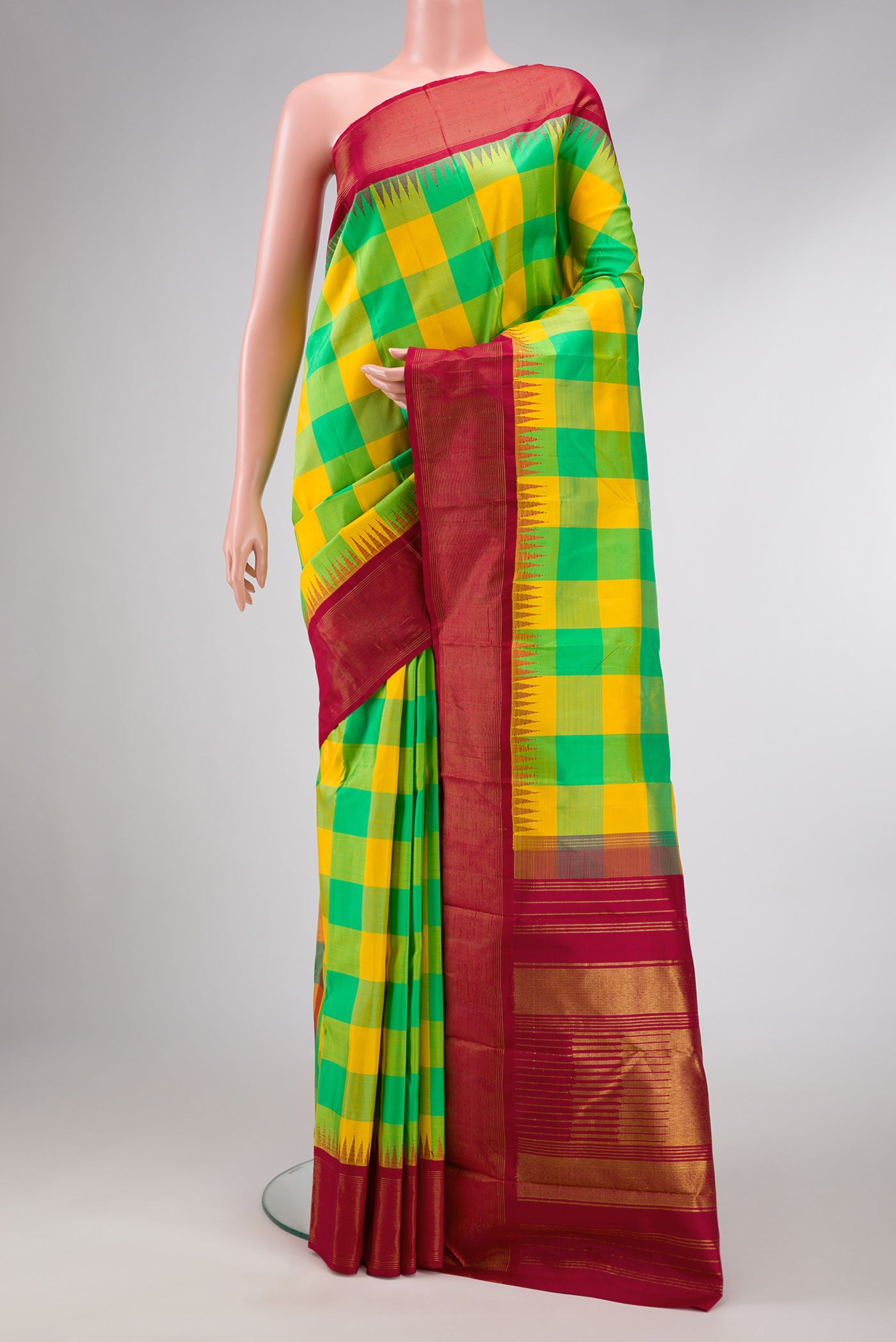 Yellow and Green Color Kanjivaram Silk Saree with Checked design on the body and Temple Border.  displayed on a mannequin