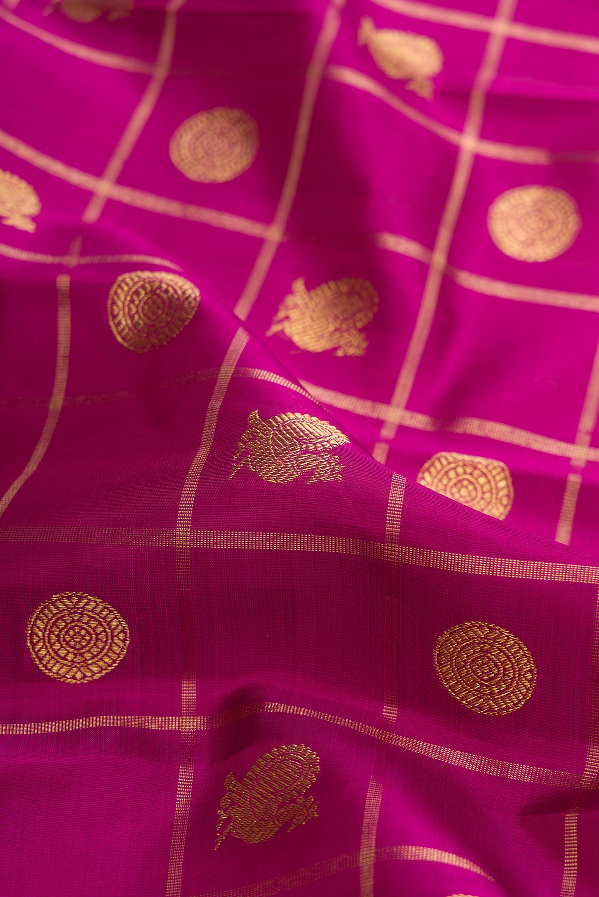 Close up of Pure Silk Pure Zari Magenta Dual Tone Kanjivaram Saree with Checked design on the body and Zari Border.  displaying folds