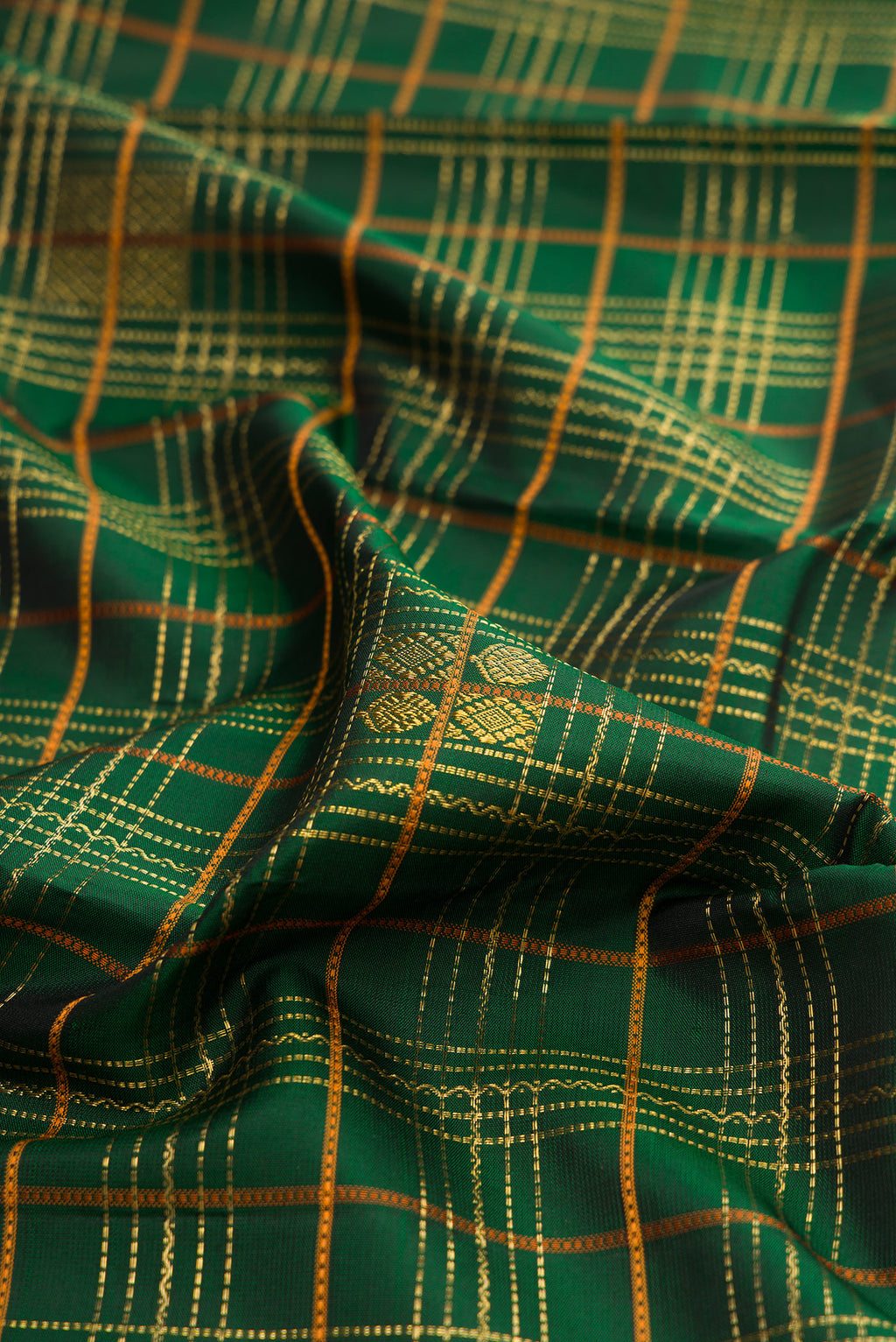 Close up of Pure Silk Bottle Green Kanjivaram Saree with Checked design on the body and Zari Border.  displaying folds