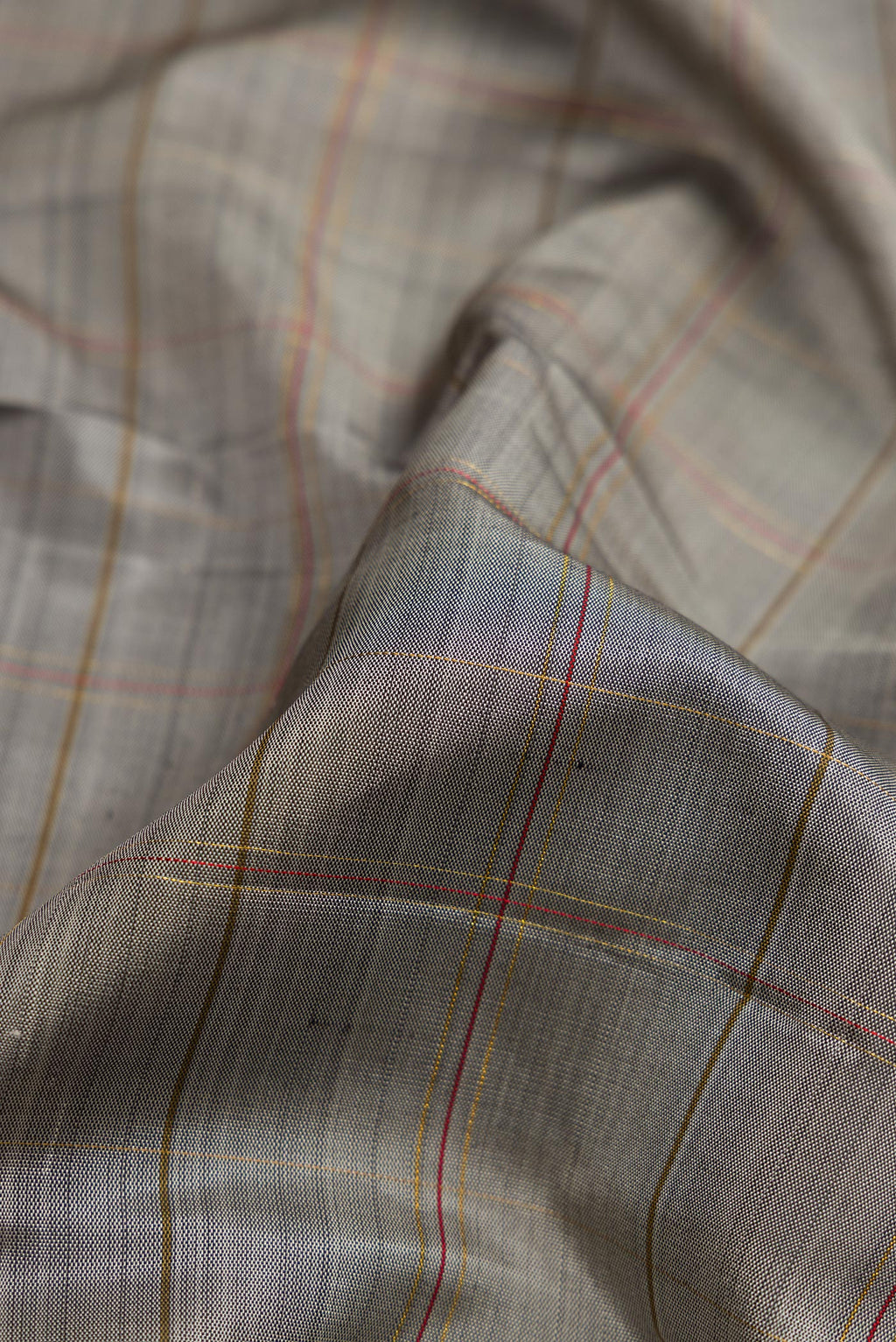 Close up of Pure Silk Pure Zari Grey Dual Tone Kanchipuram Saree with Checked design on the body and Zari Border.  displaying folds