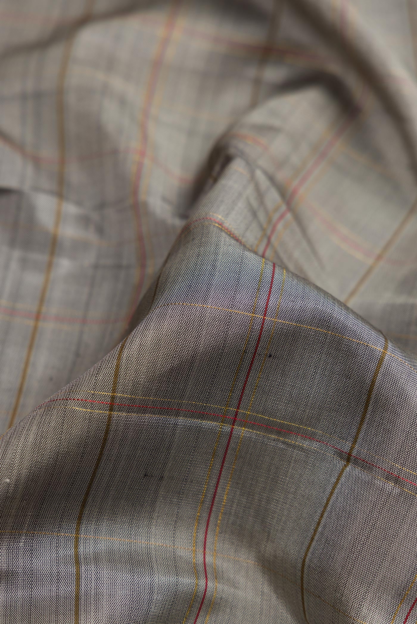 Close up of Pure Silk Pure Zari Grey Dual Tone Kanchipuram Saree with Checked design on the body and Zari Border.  displaying folds