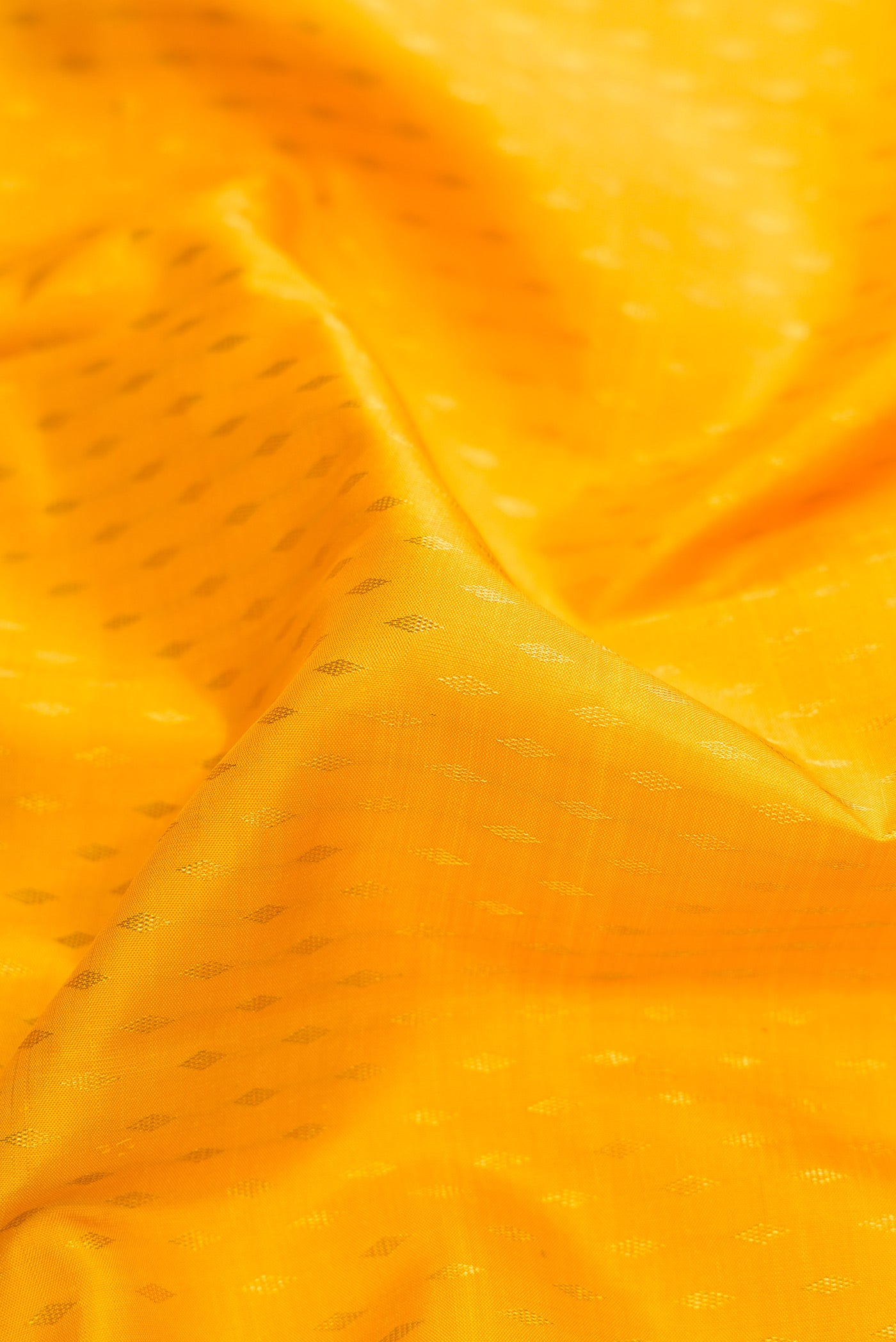Close up of Yellow Dual Tone Kanjivaram Silk Saree with Zari Butta on the body and Zari Border.  displaying folds