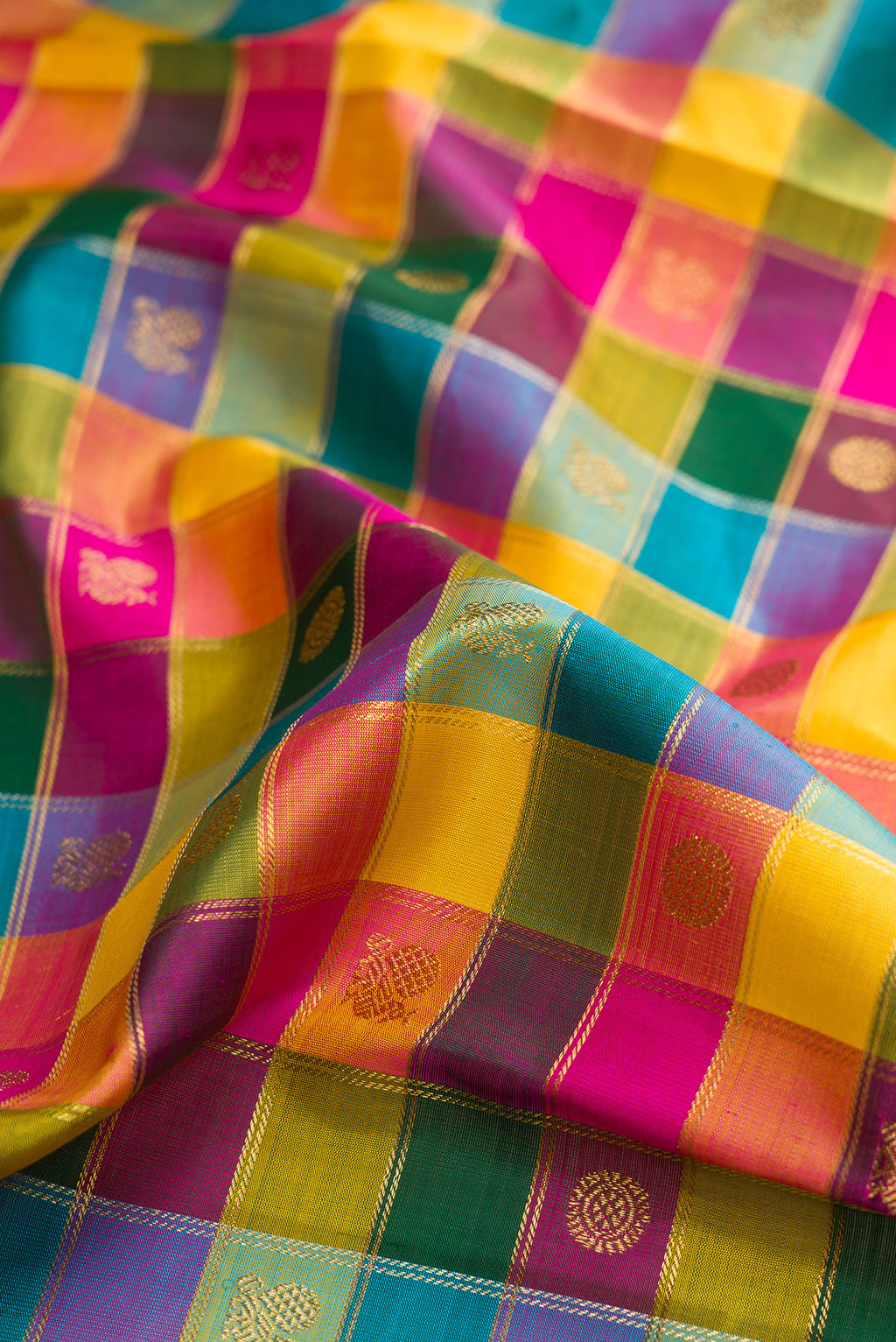 Close up of Pure Silk Pure Zari Bottle Green, Pink and Yellow Color Kanchipuram Saree with Checked design on the body and Zari Border.  displaying folds