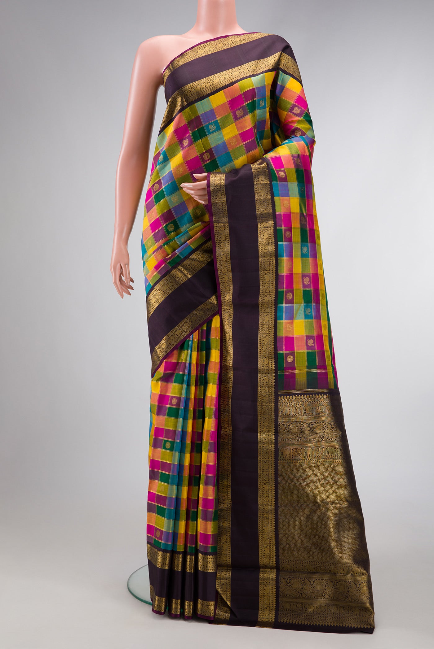 Pure Silk Pure Zari Bottle Green, Pink and Yellow Color Kanchipuram Saree with Checked design on the body and Zari Border.  displayed on a mannequin