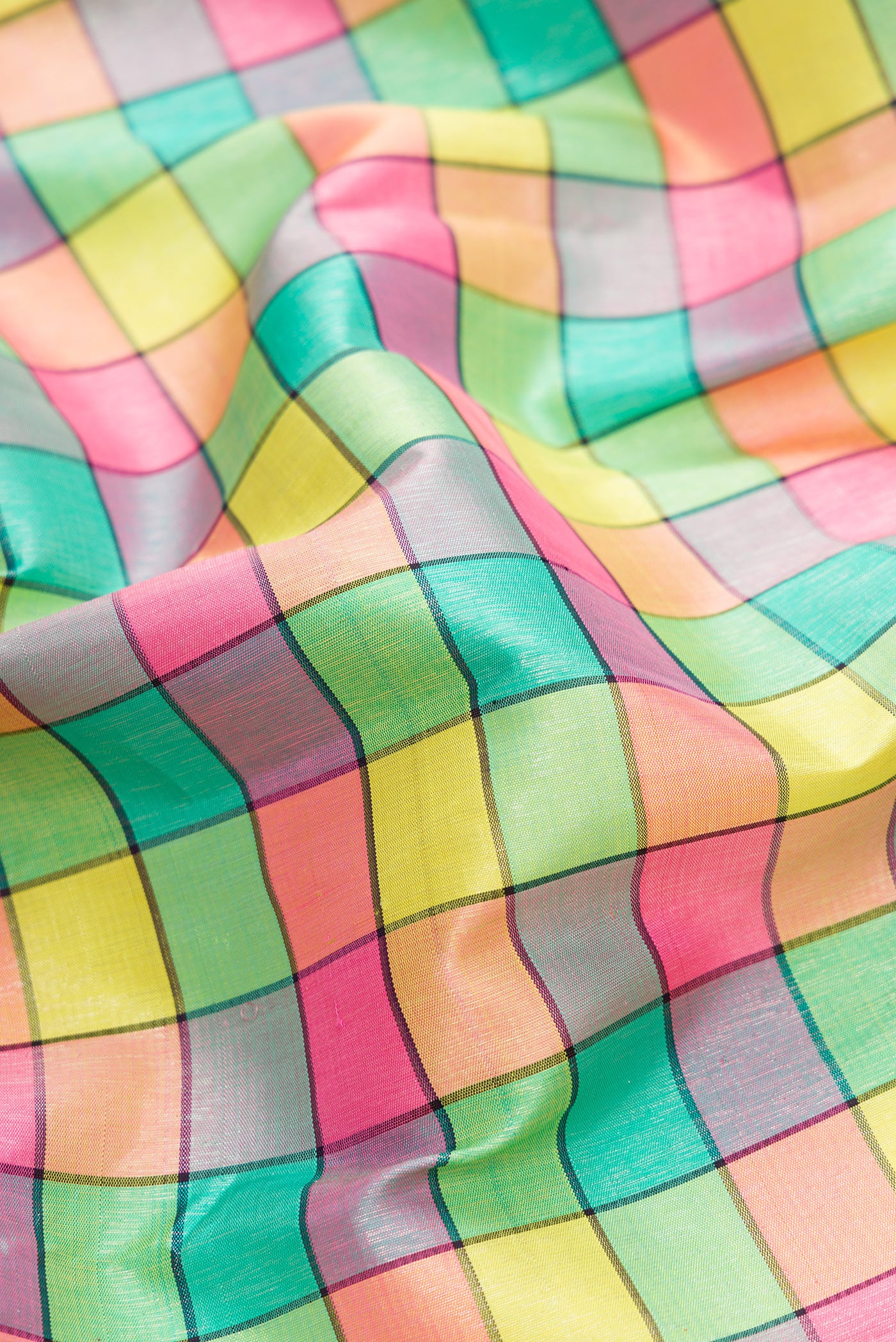 Close up of Pure Silk Pure Zari Green, Pink, Peach and Yellow Color Kanjivaram Saree with Checked design on the body and Fancy Border.  displaying folds