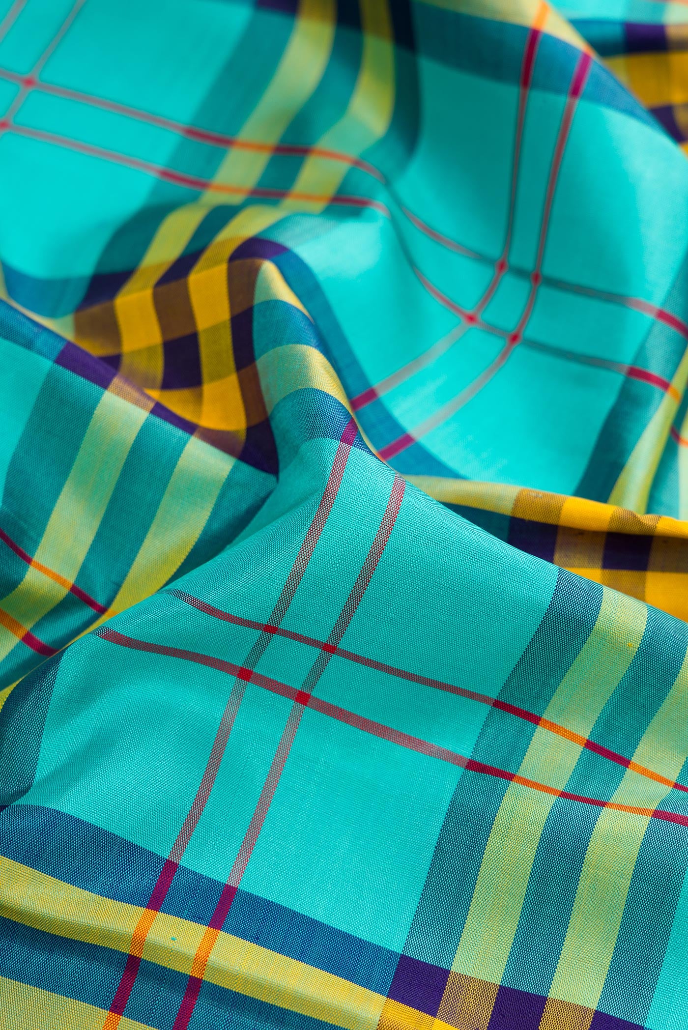 Close up of Pure Silk Pure Zari Multi Color Kanjivaram Saree with Checked design on the body and Fancy Border.  displaying folds