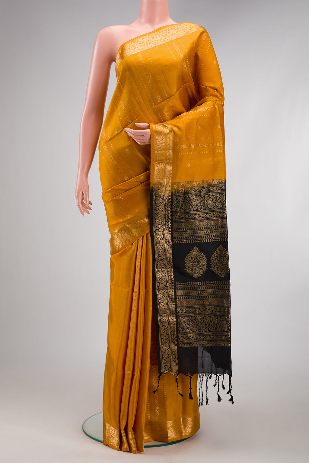 Mustard Soft Silk Saree with Zari Butta on the body and Zari Border.  displayed on a mannequin