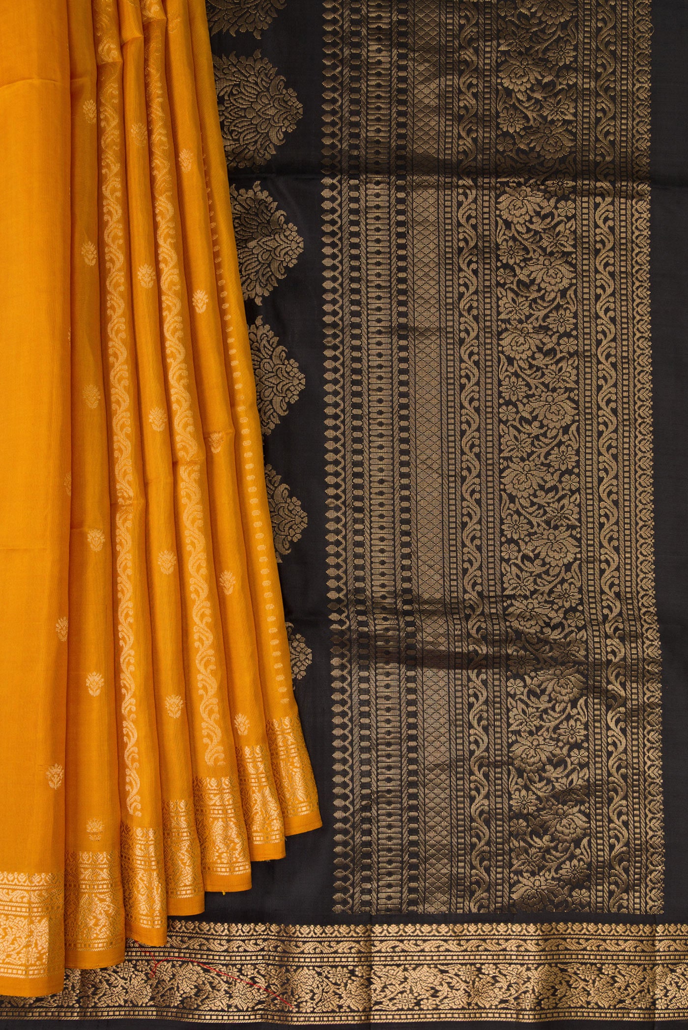 Pleats and pallu of Mustard Soft Silk Saree with Zari Butta on the body and Zari Border. 
