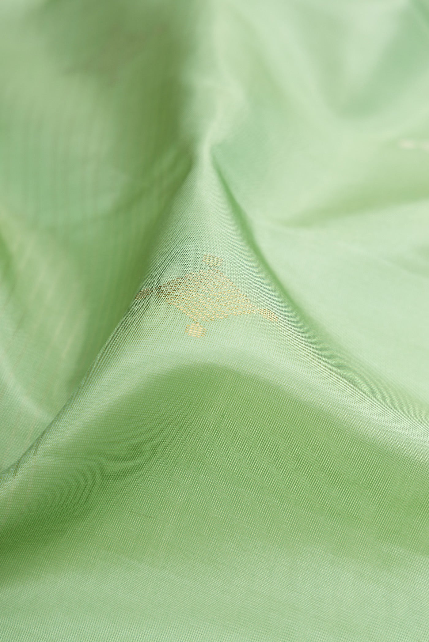 Close up of Pista Green Soft Silk Saree with Stripes on the body and Without Border.  displaying folds