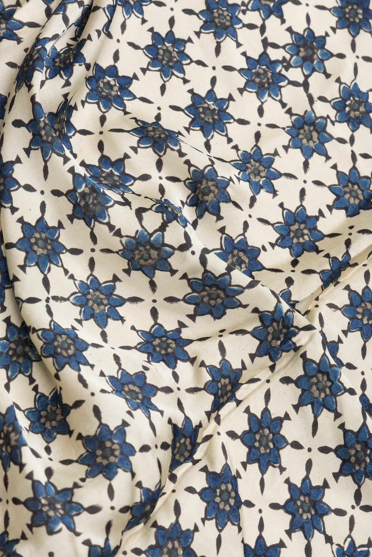 Close up of Beige Dual Tone Blended Satin Crepe Saree with Printed design on the body and Printed Border.  displaying folds