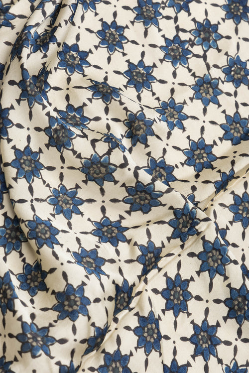 Close up of Beige Dual Tone Blended Satin Crepe Saree with Printed design on the body and Printed Border.  displaying folds