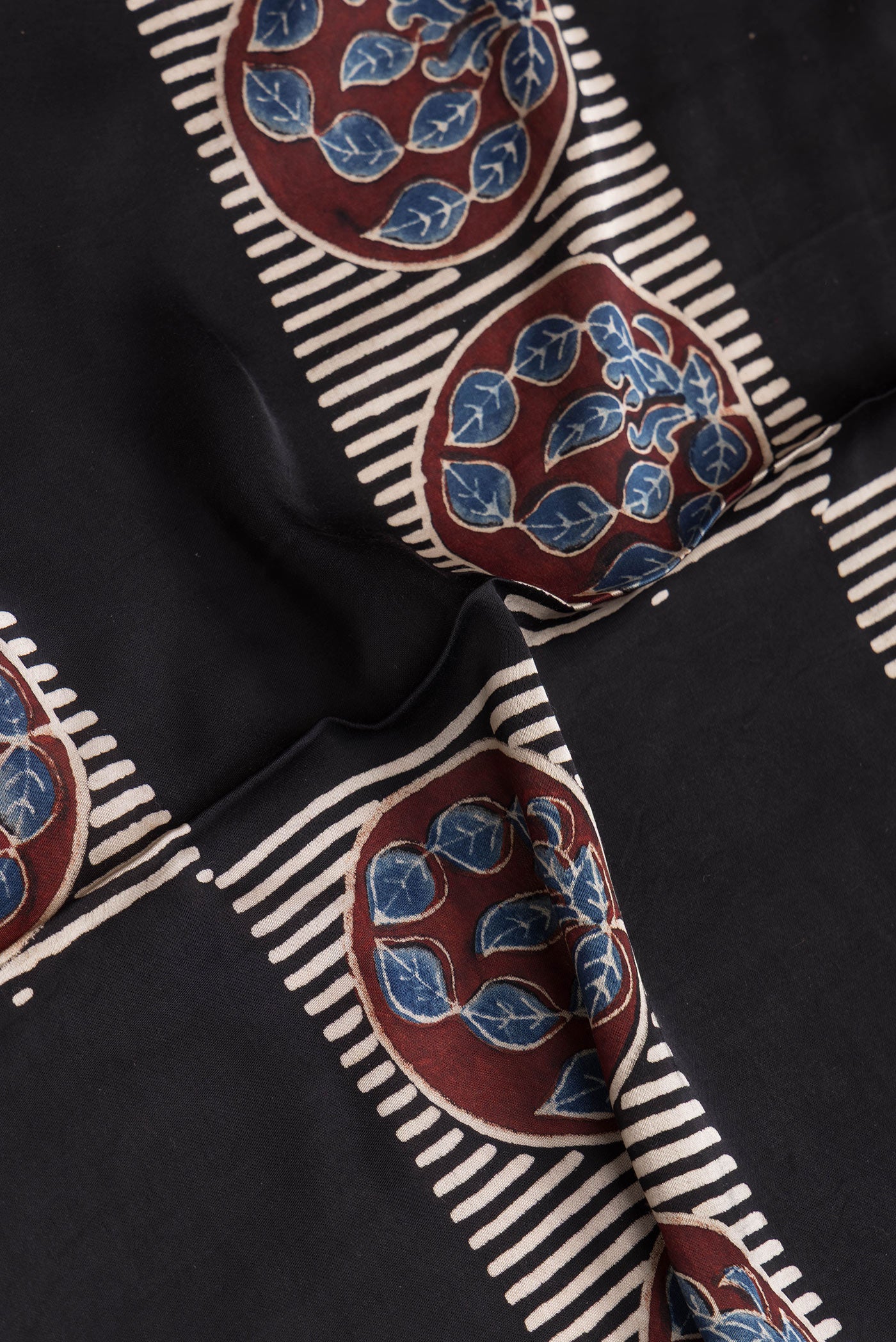 Close up of Black Dual Tone Blended Satin Crepe Saree with Printed design on the body and Printed Border.  displaying folds
