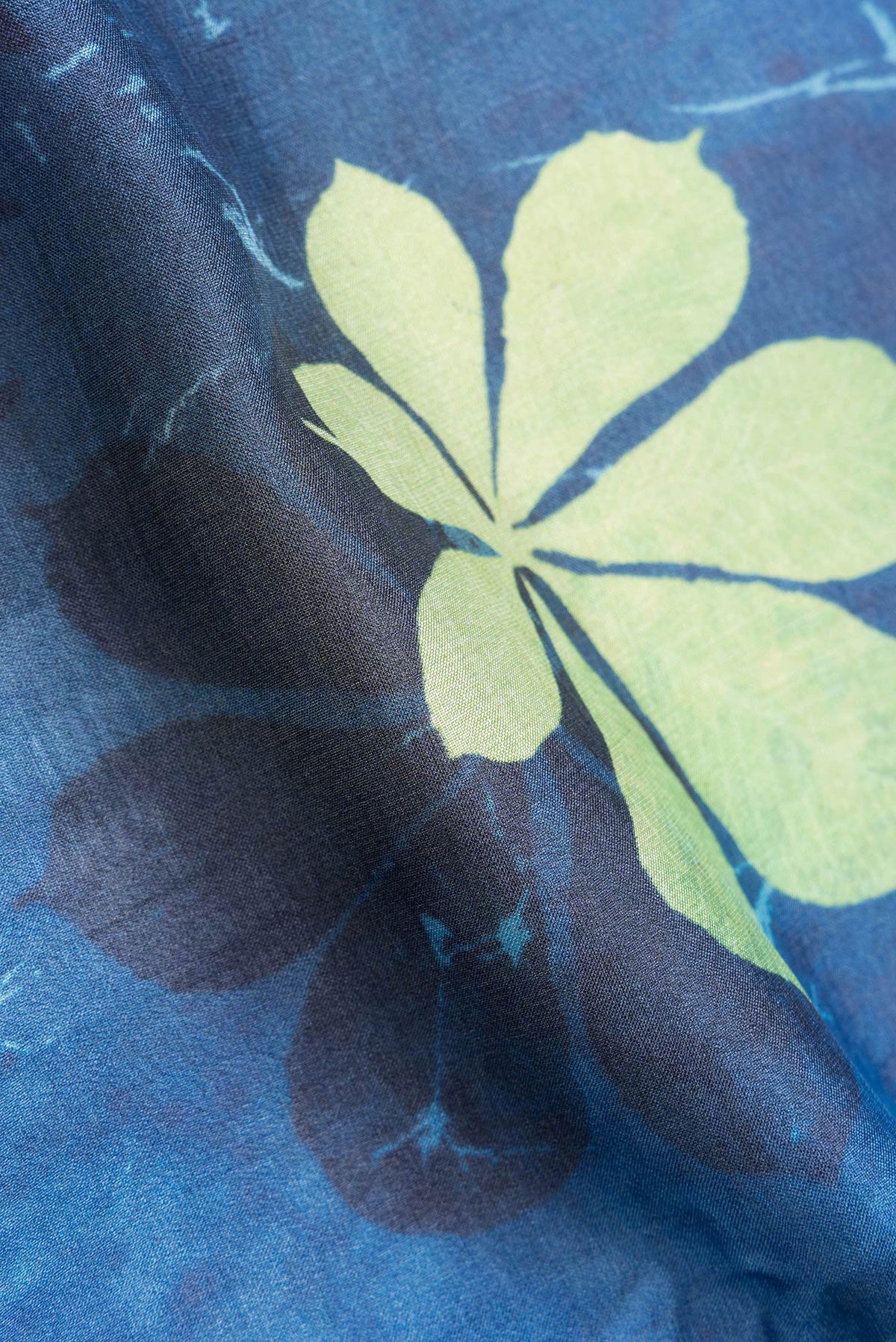 Close up of Peacock Blue Dual Tone Tussar Silk Saree with Printed design on the body and Zari Border.  displaying folds