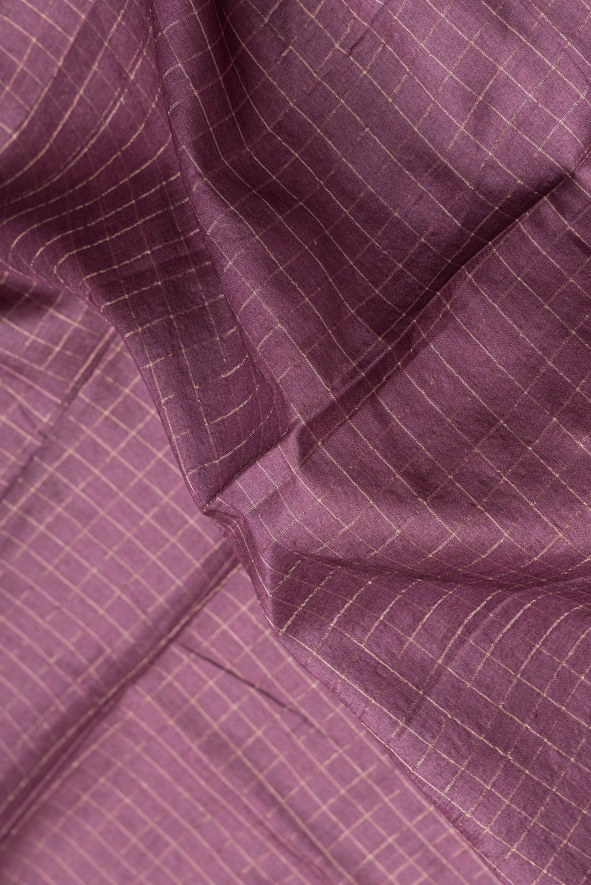 Close up of Burgundy Dual Tone Tussar Silk Saree with Checked design on the body and Zari Border.  displaying folds
