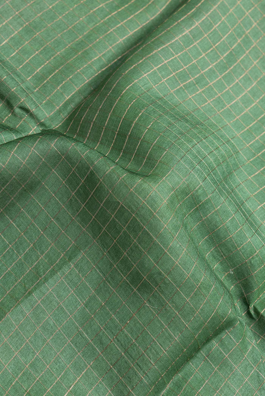 Close up of Bottle Green Dual Tone Tussar Silk Saree with Checked design on the body and Printed Border.  displaying folds